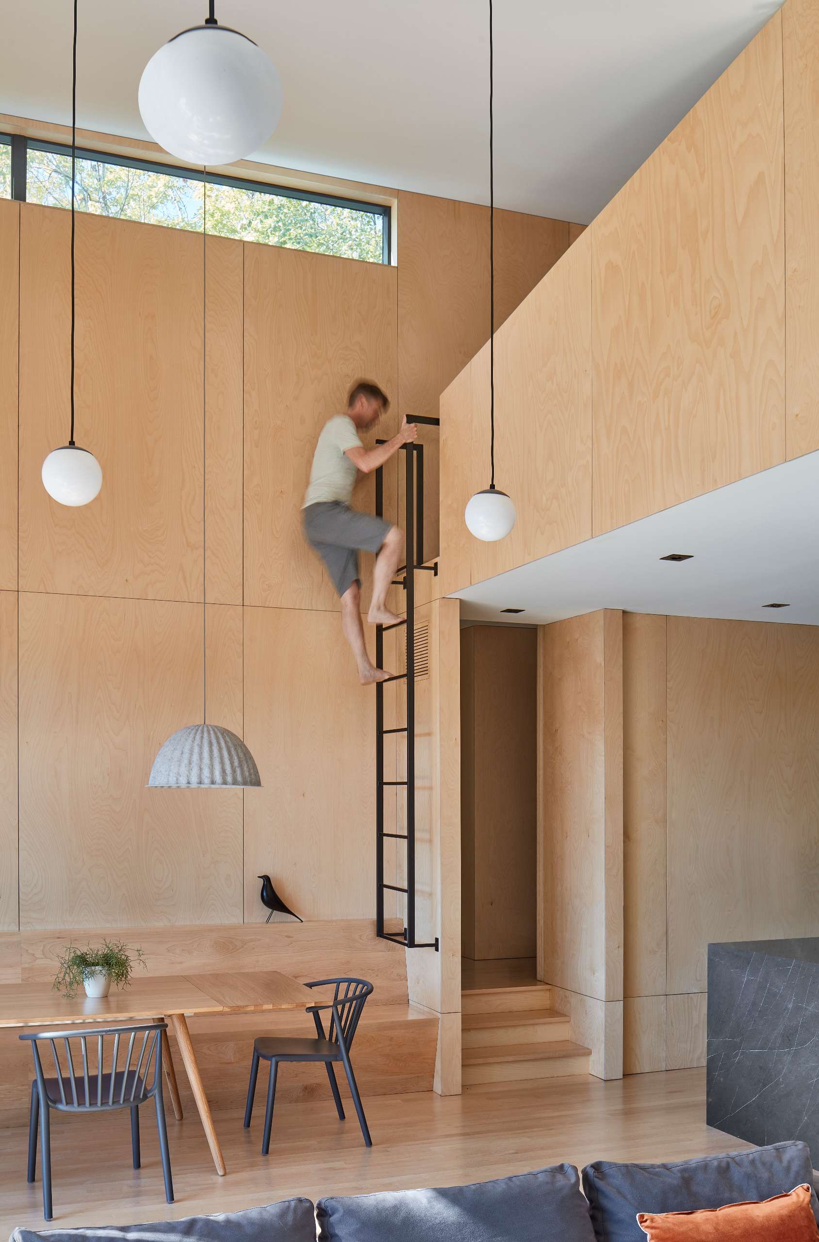 Where the rooflines converge, a loft space provides a cool hangout for teenagers, creating an intimate nook above the open floor plan that overlooks the double-height living area.