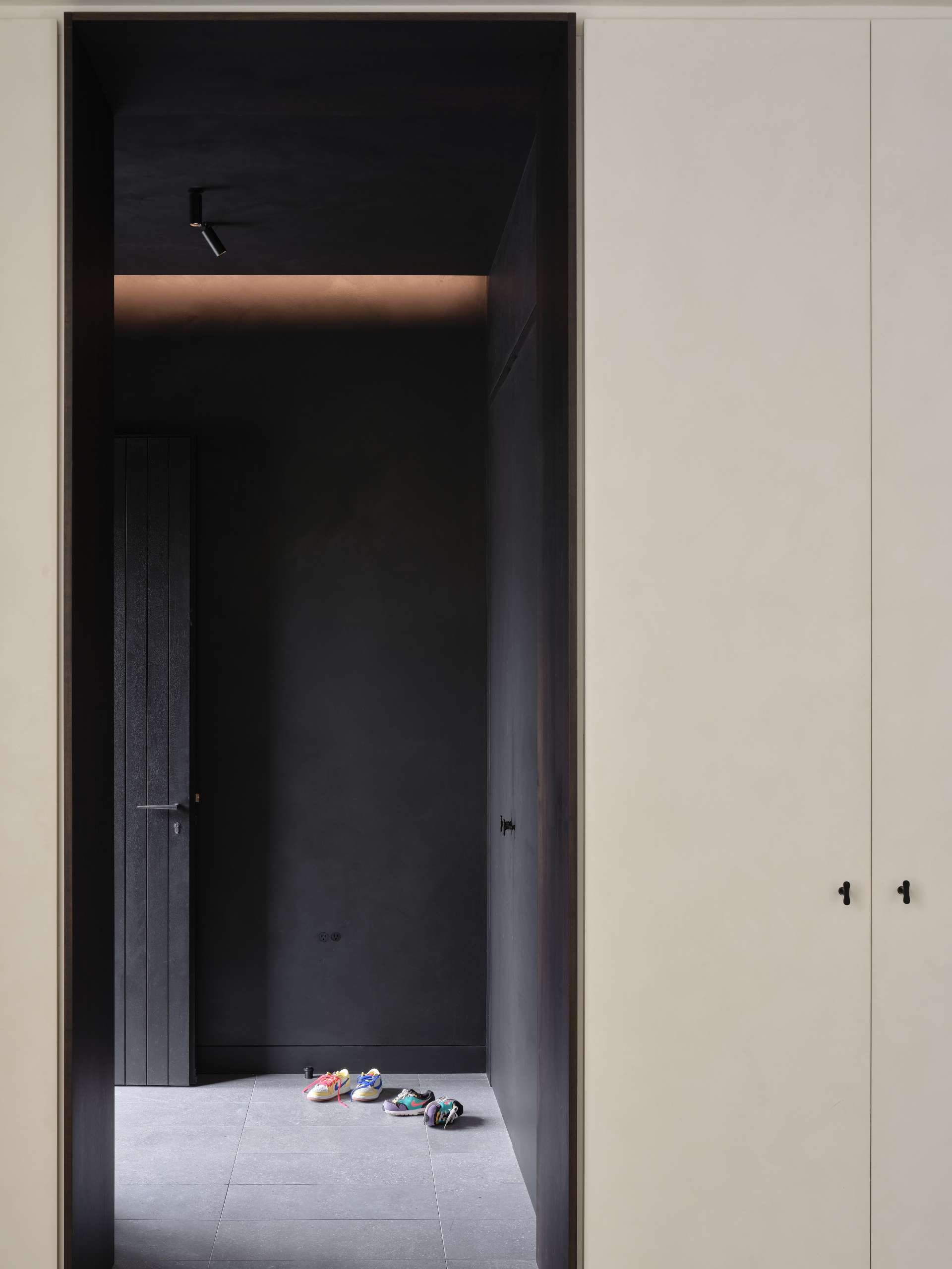 Interior materials are equally deliberate, expressing a tension between dark, tactile drama and bright, welcoming softness.