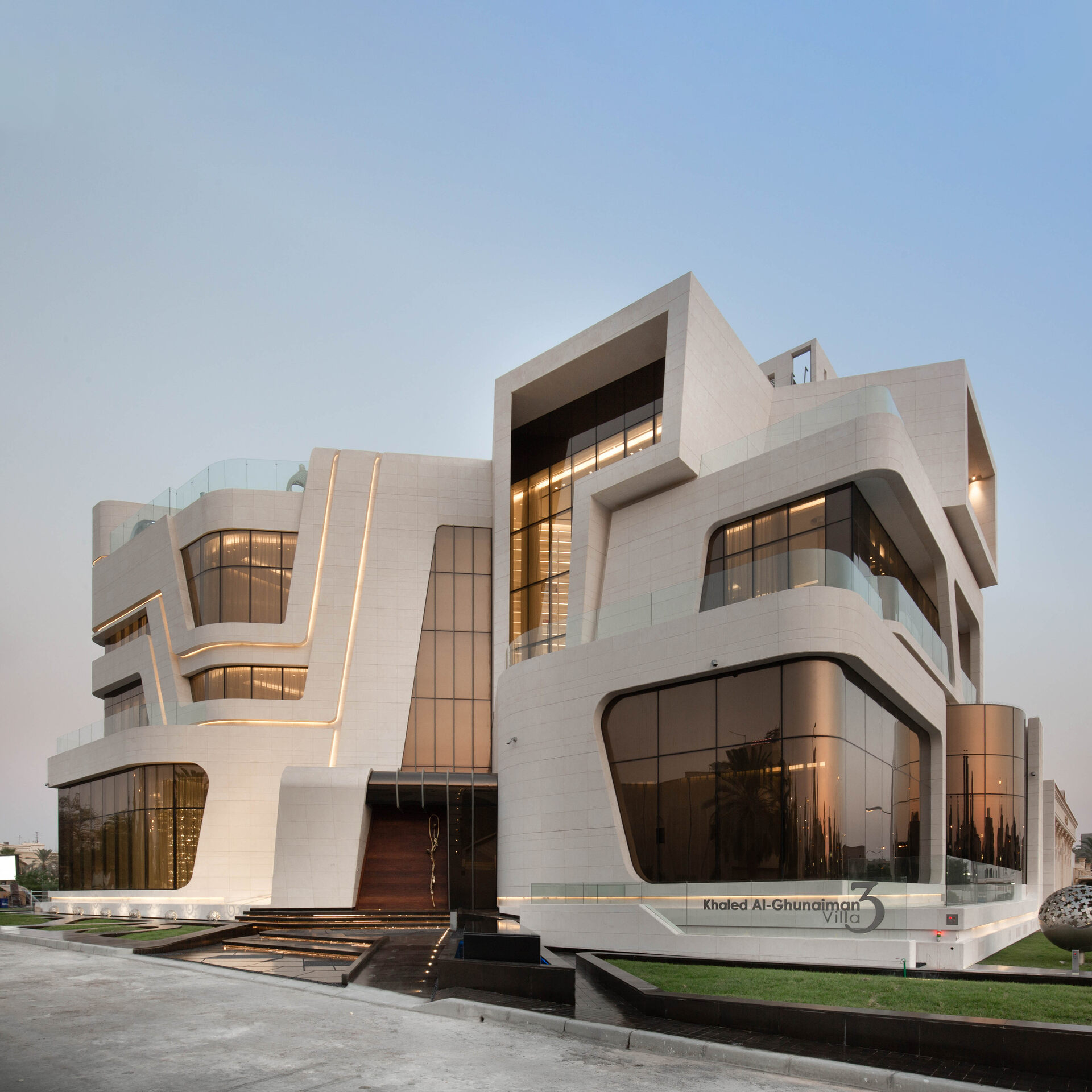 This ultra-modern villa with its fluid architecture, seamlessly integrates with nature, featuring expansive glass walls and minimalist interiors, while organic shapes and a subdued color palette evoke a sense of tranquility and sophistication.