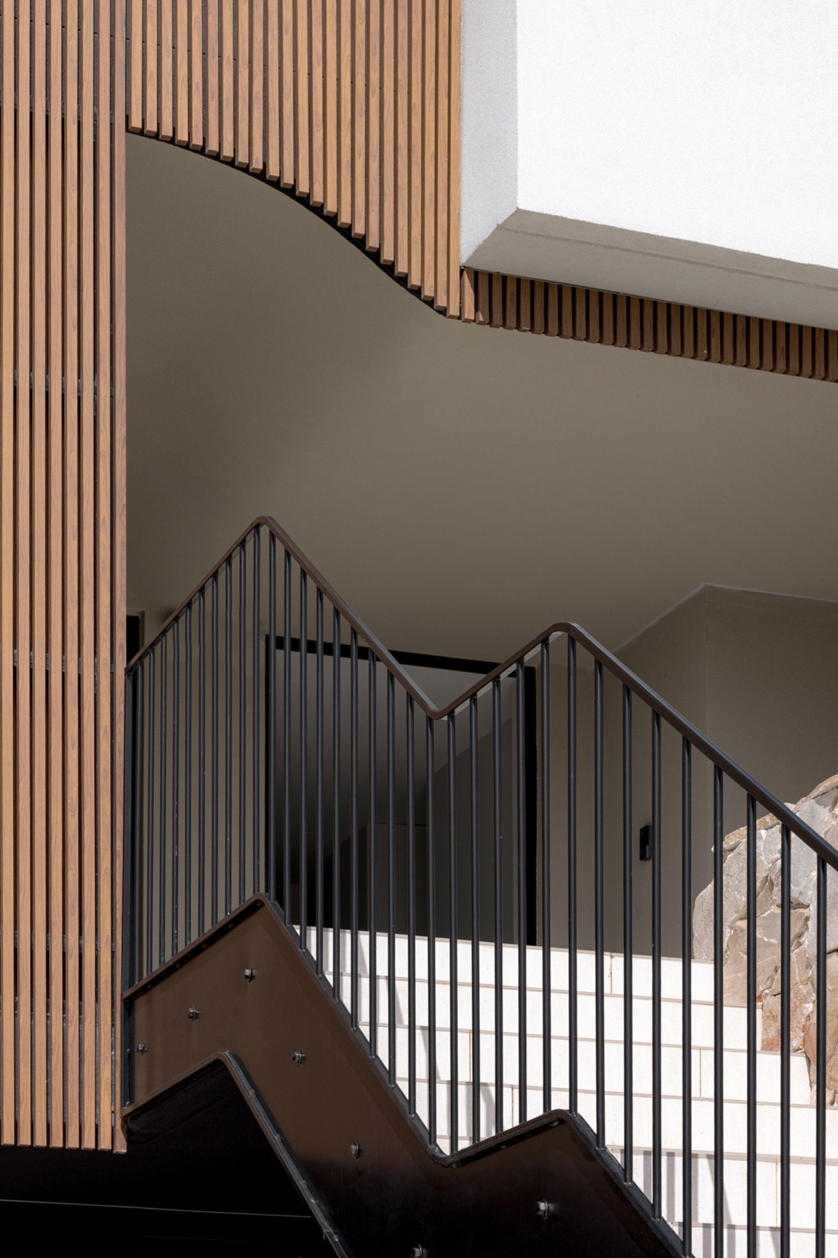 A modern home with wood details and curves on the facade.