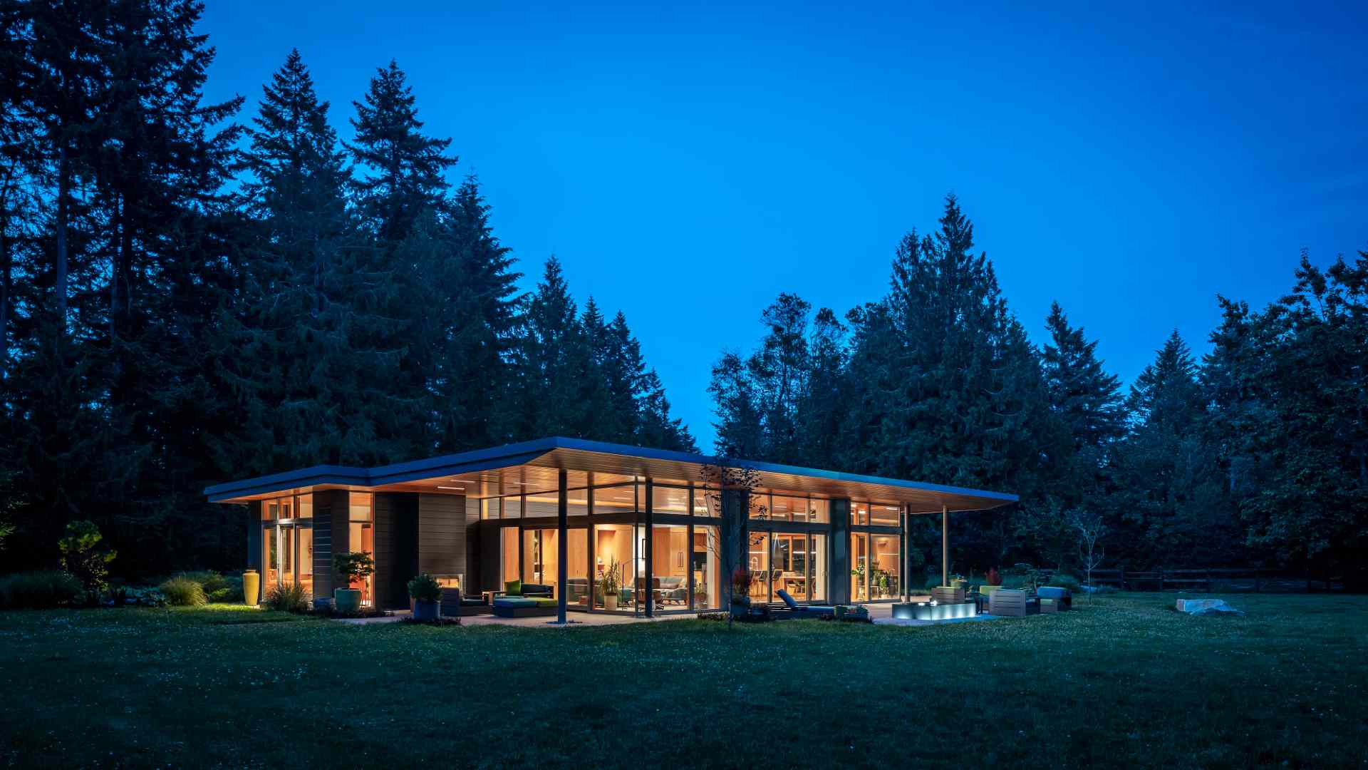 A single tapered roof ties together this home, carriage house, and sauna creating a generous covered entry promenade.