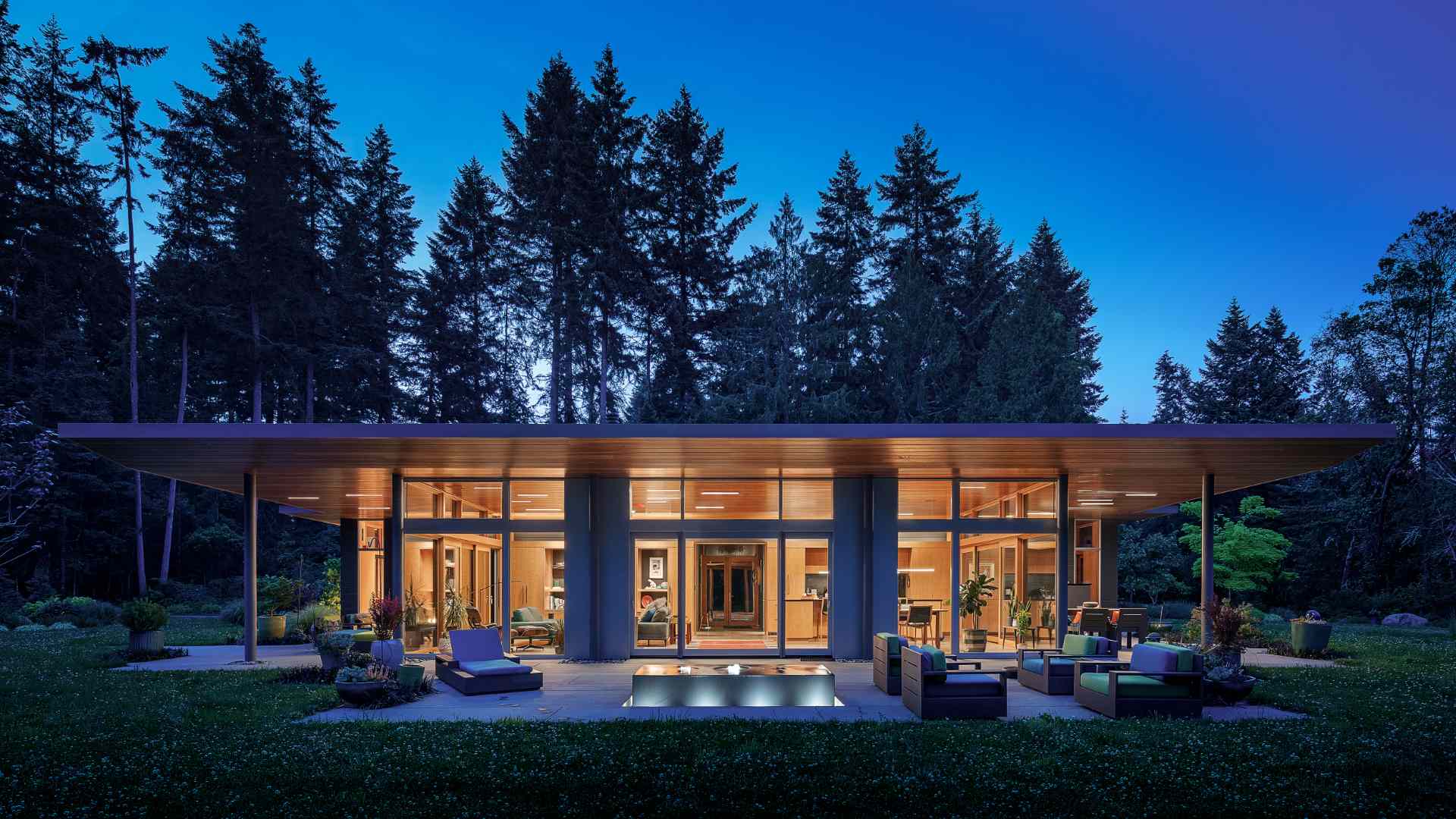 A single tapered roof ties together this home, carriage house, and sauna creating a generous covered entry promenade.