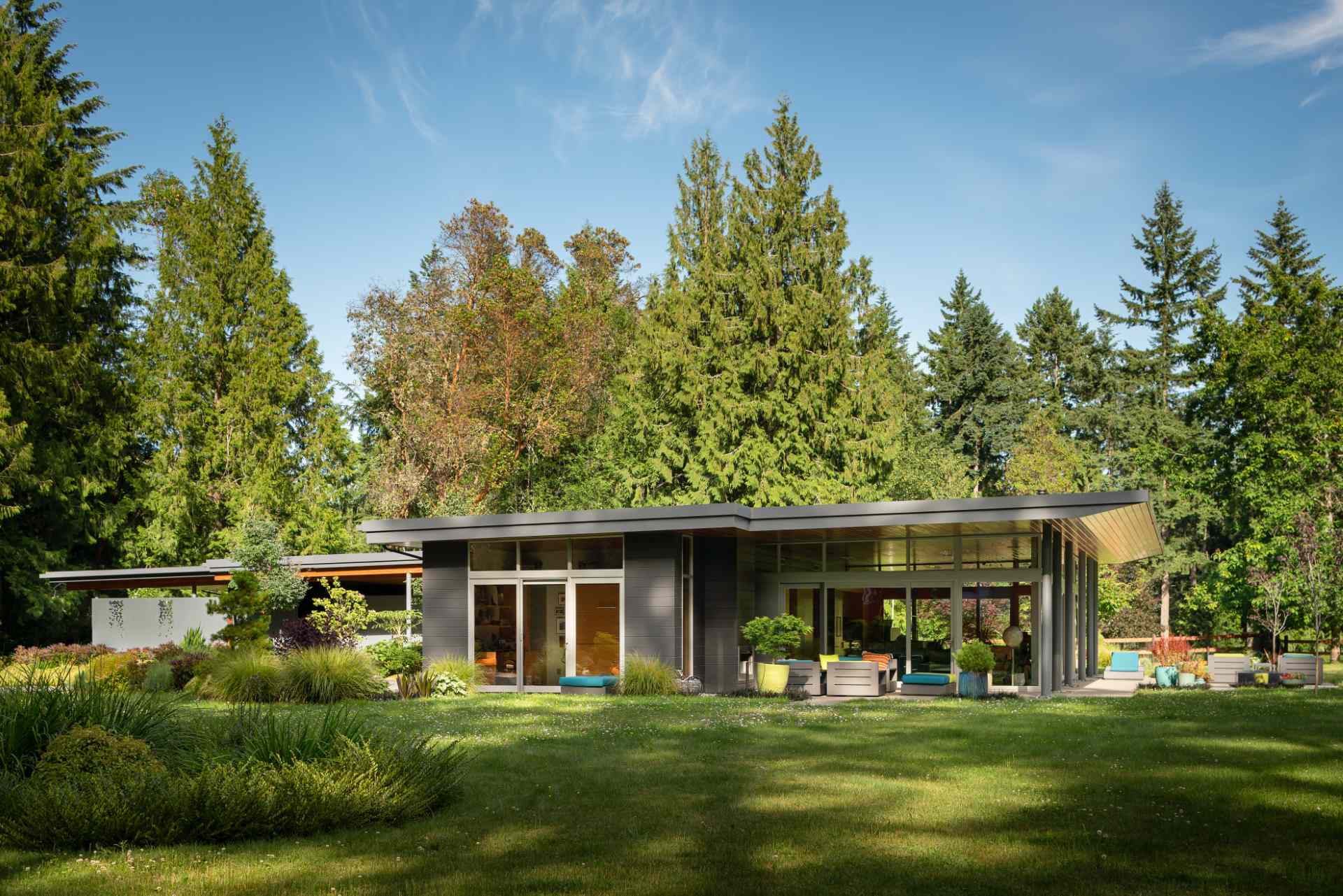 A single tapered roof ties together this home, carriage house, and sauna creating a generous covered entry promenade.