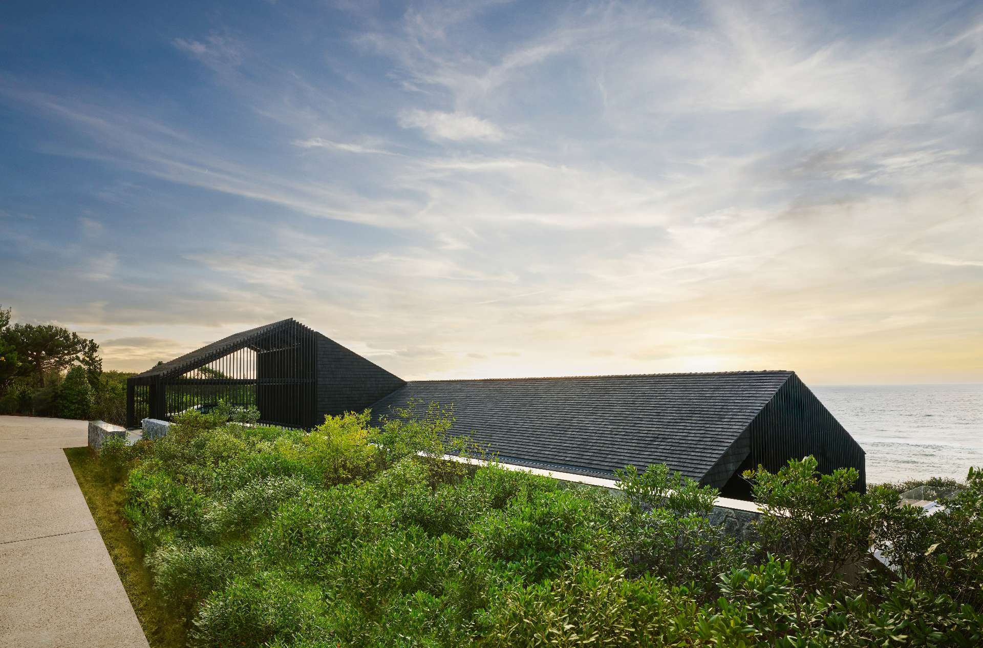 Clad in shou sugi ban, a charred timber technique known for its weather resistance, this dark, sculptural volume anchors the home in local architectural tradition, while offering durability against the coastal climate.