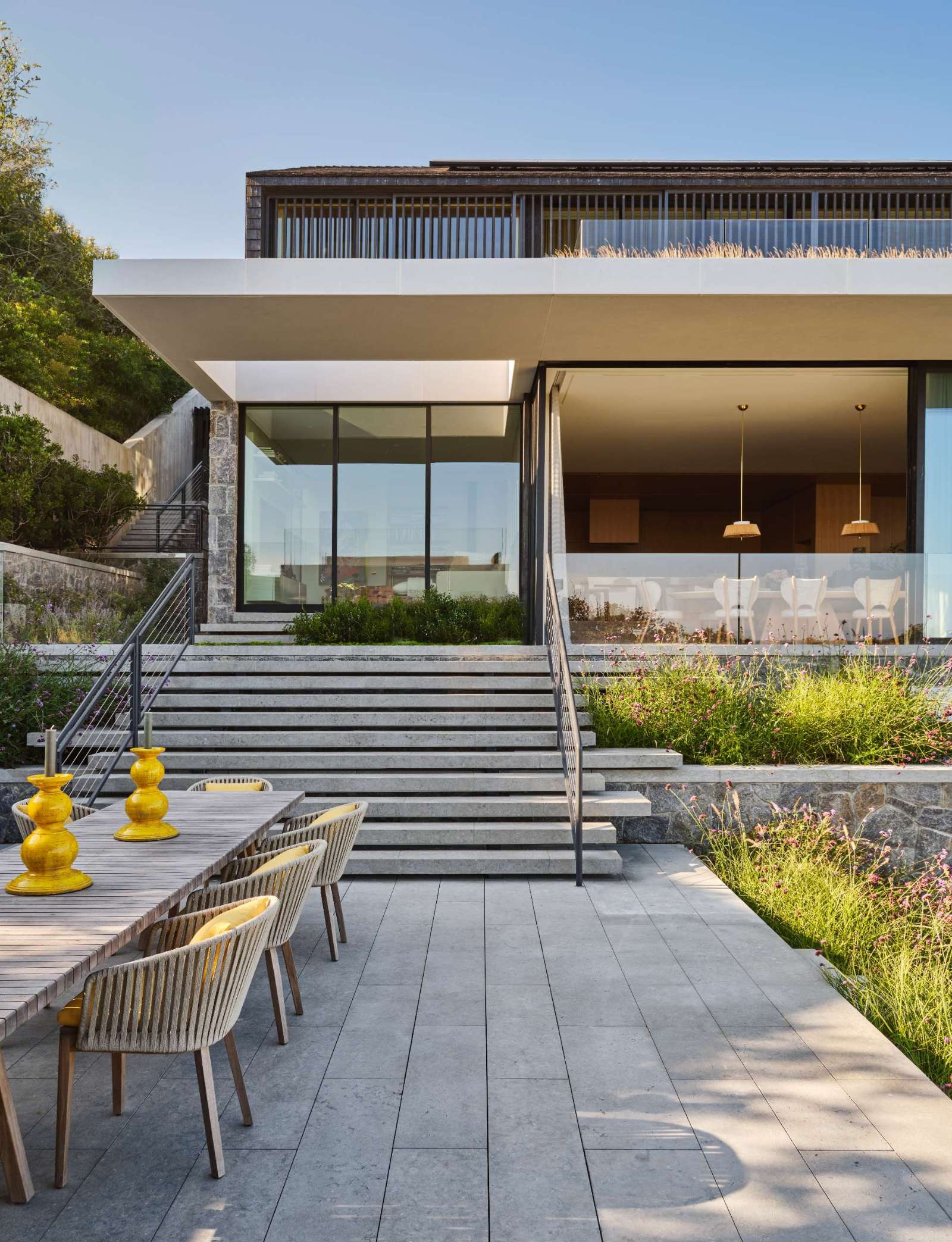 This modern home has three distinct levels to it, while outside, there's a terraced backyard with swimming pool, outdoor kitchen, and pool house.