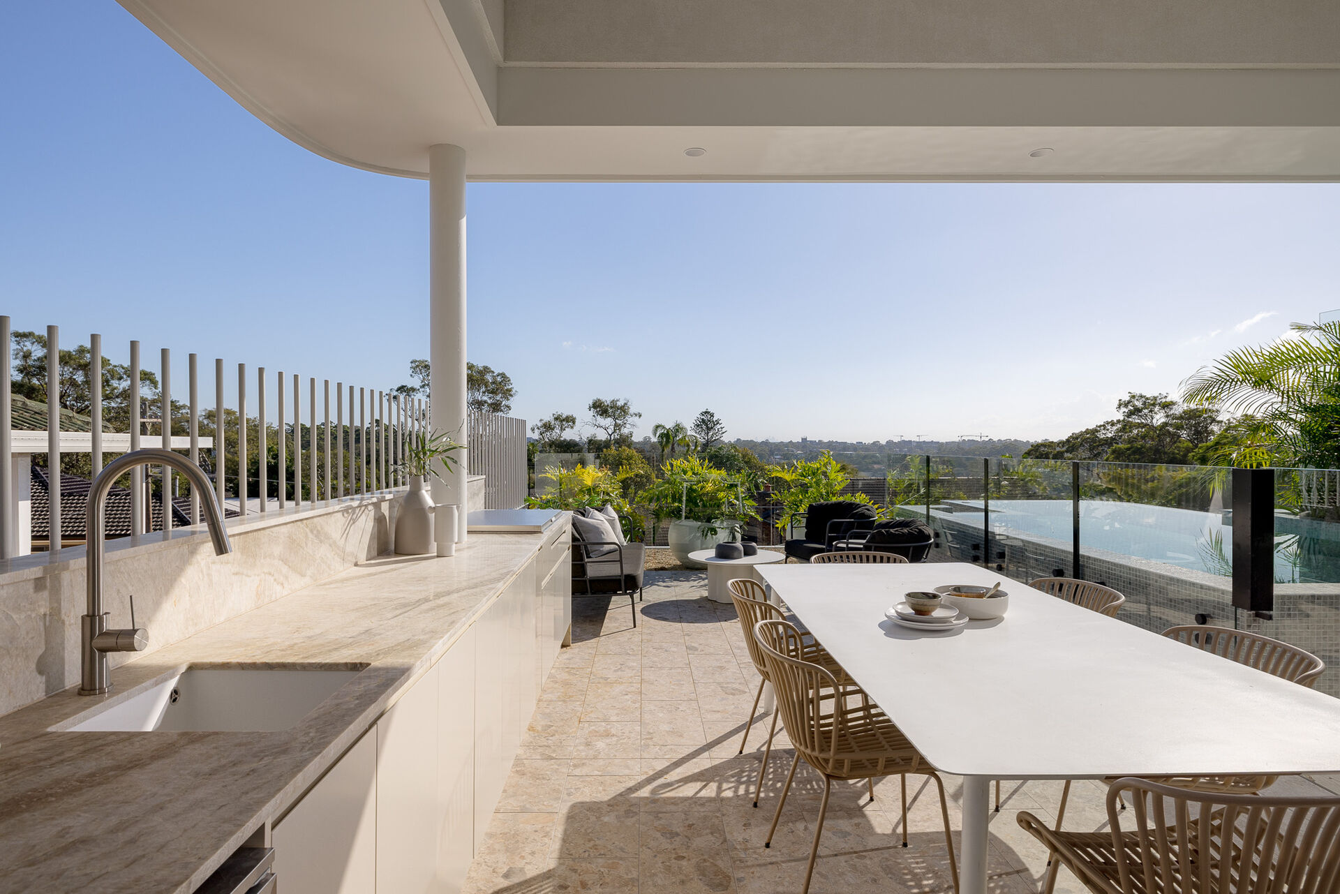 The living room and kitchen open to the outdoor space, where there's a bbq area, outdoor dining, and a swimming pool.