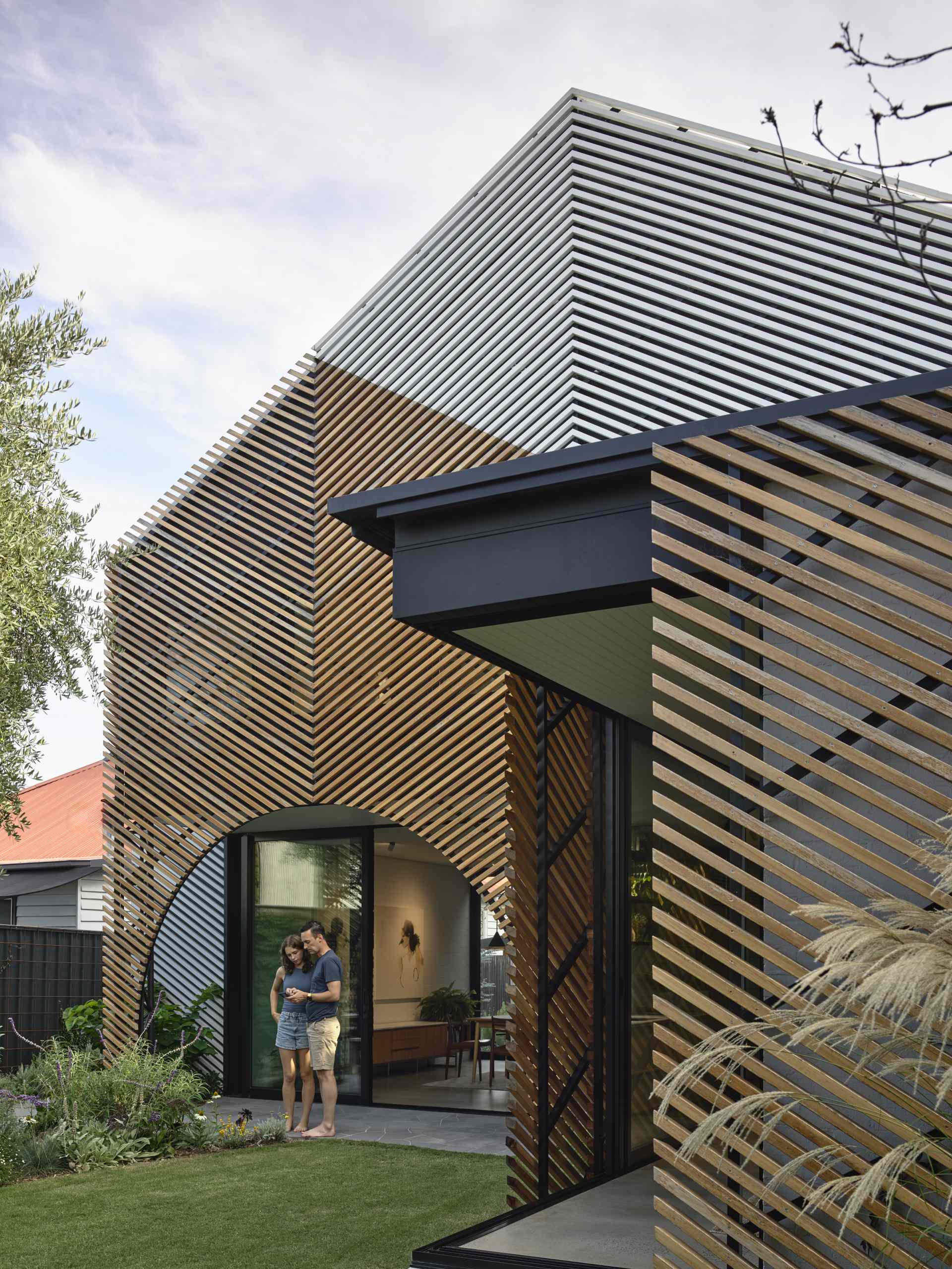 A batten screen was used to unify the rear extension with the original home, bringing together the addition in a simple meeting of forms, while providing shade and protection, restricting overlooking, and creating a covered verandah.