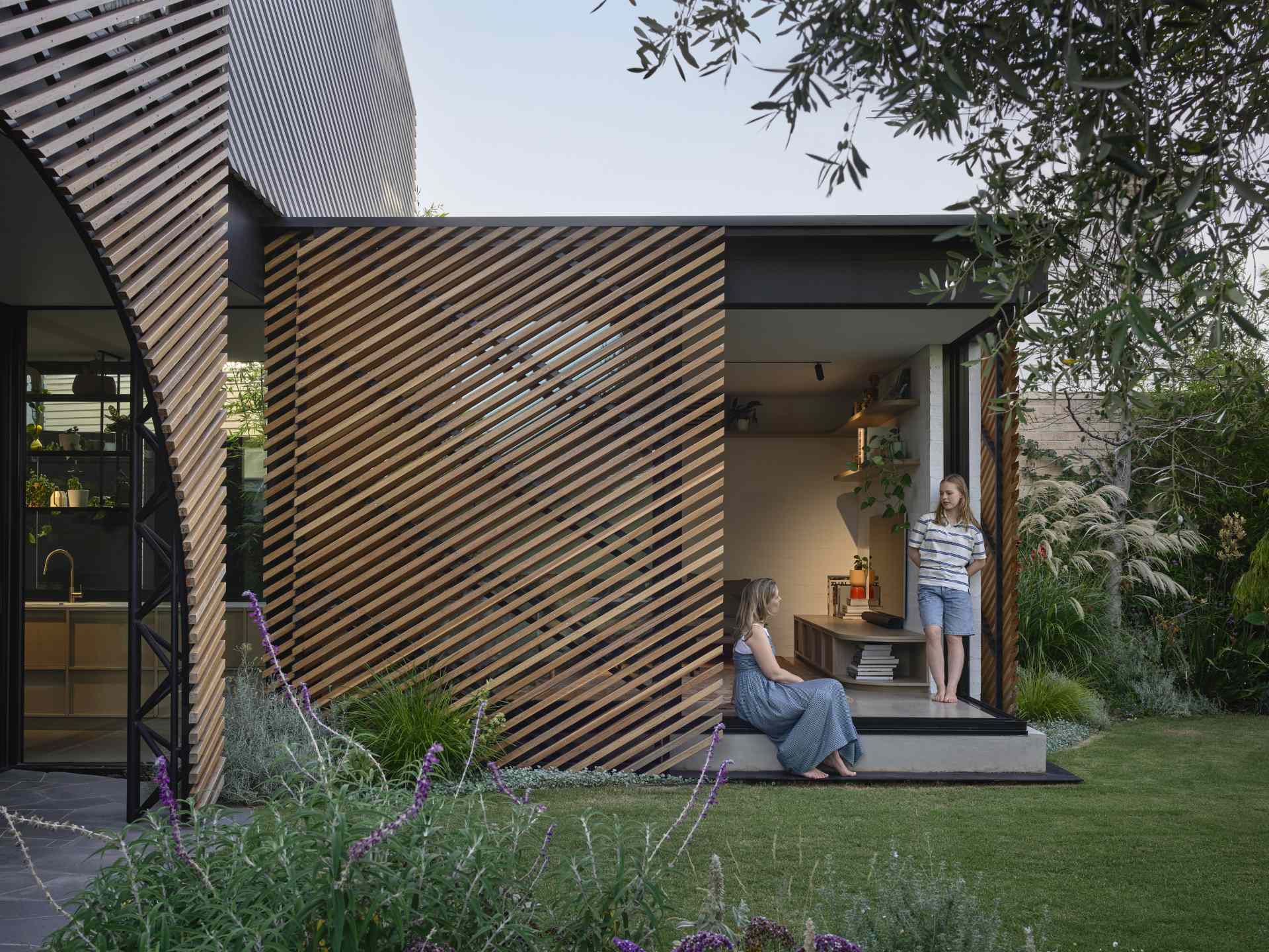 The screen and the full height glass windows in the lounge pavilion also slide away at the corner, to fully open up into the garden.