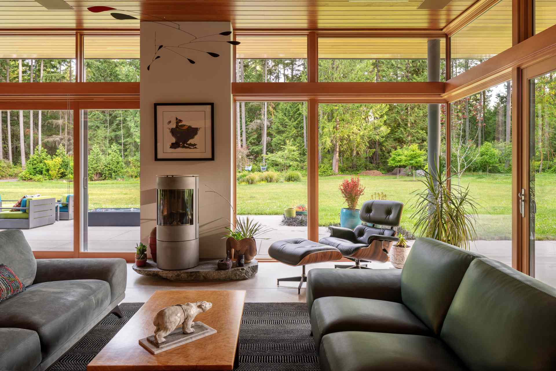 In this living room, natural light floods the interior, while a fireplace keeps things warm and custom-designed cabinetry hides the TV and a workspace when not in use.