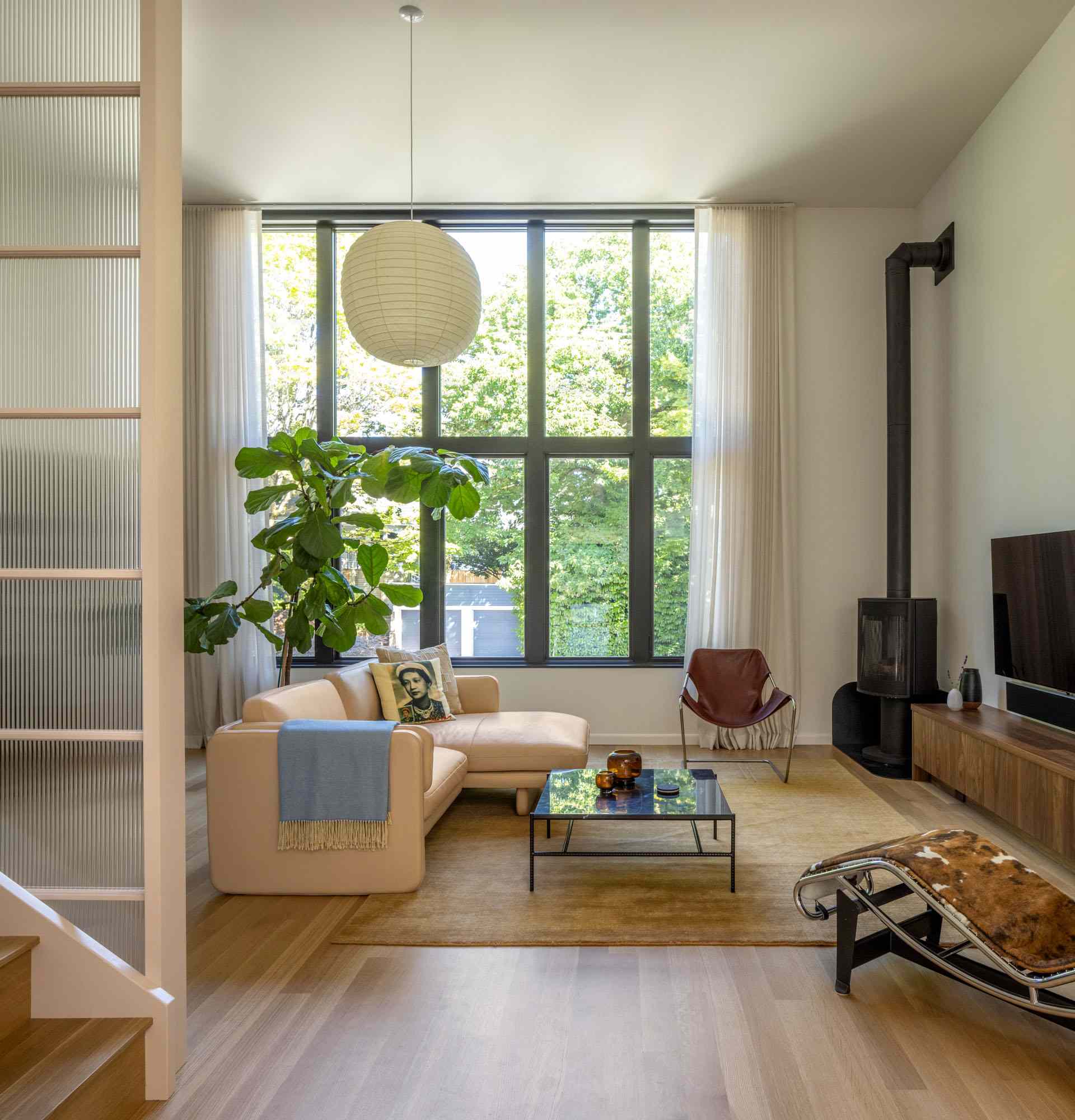 Inside, the original north studio window was enlarged to retain the same north light. The main level of the home now includes a living room, dining room, and kitchen.