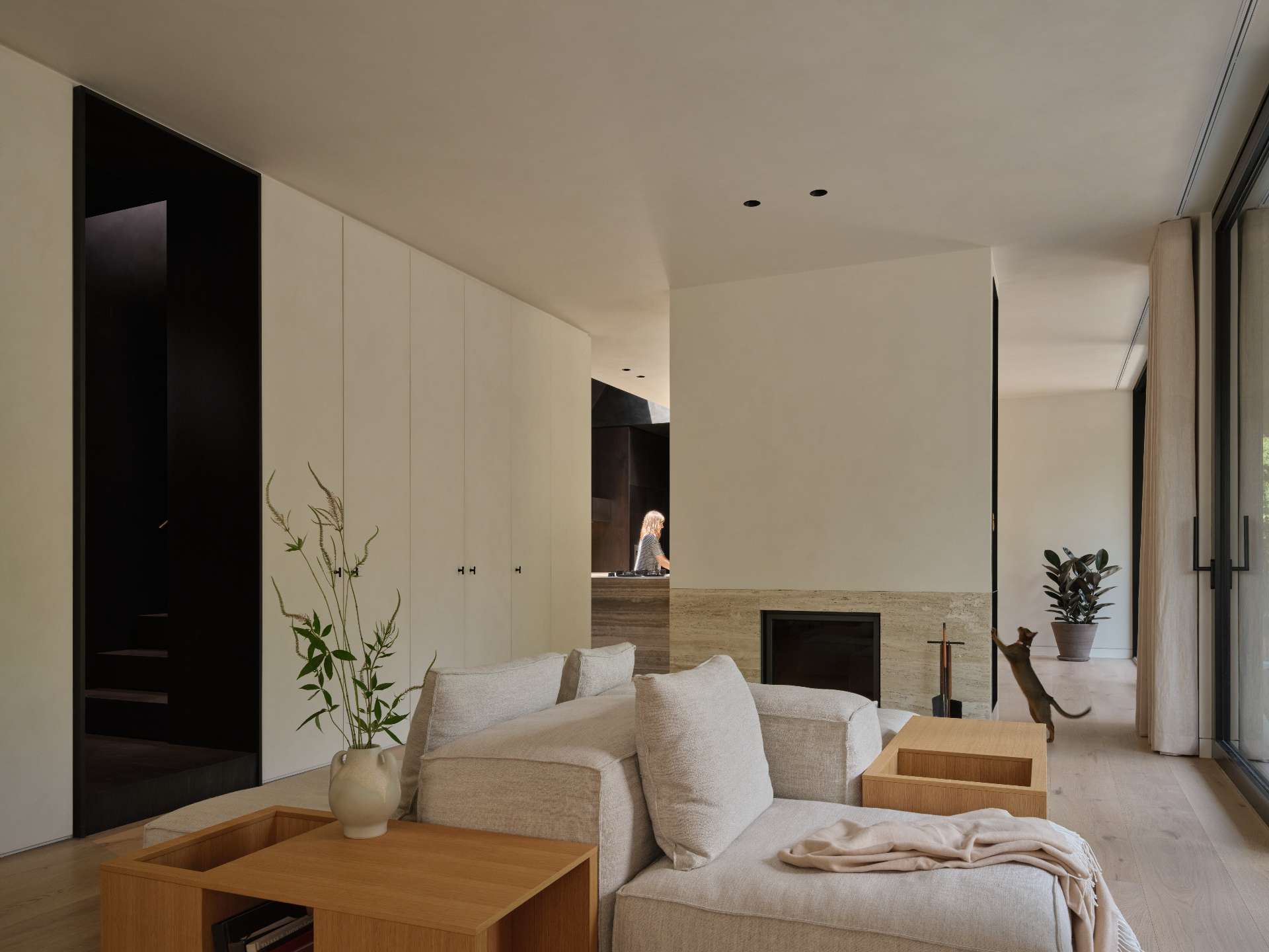 A central travertine fireplace serves as both a functional element and a sculptural focal point, anchoring this living room.