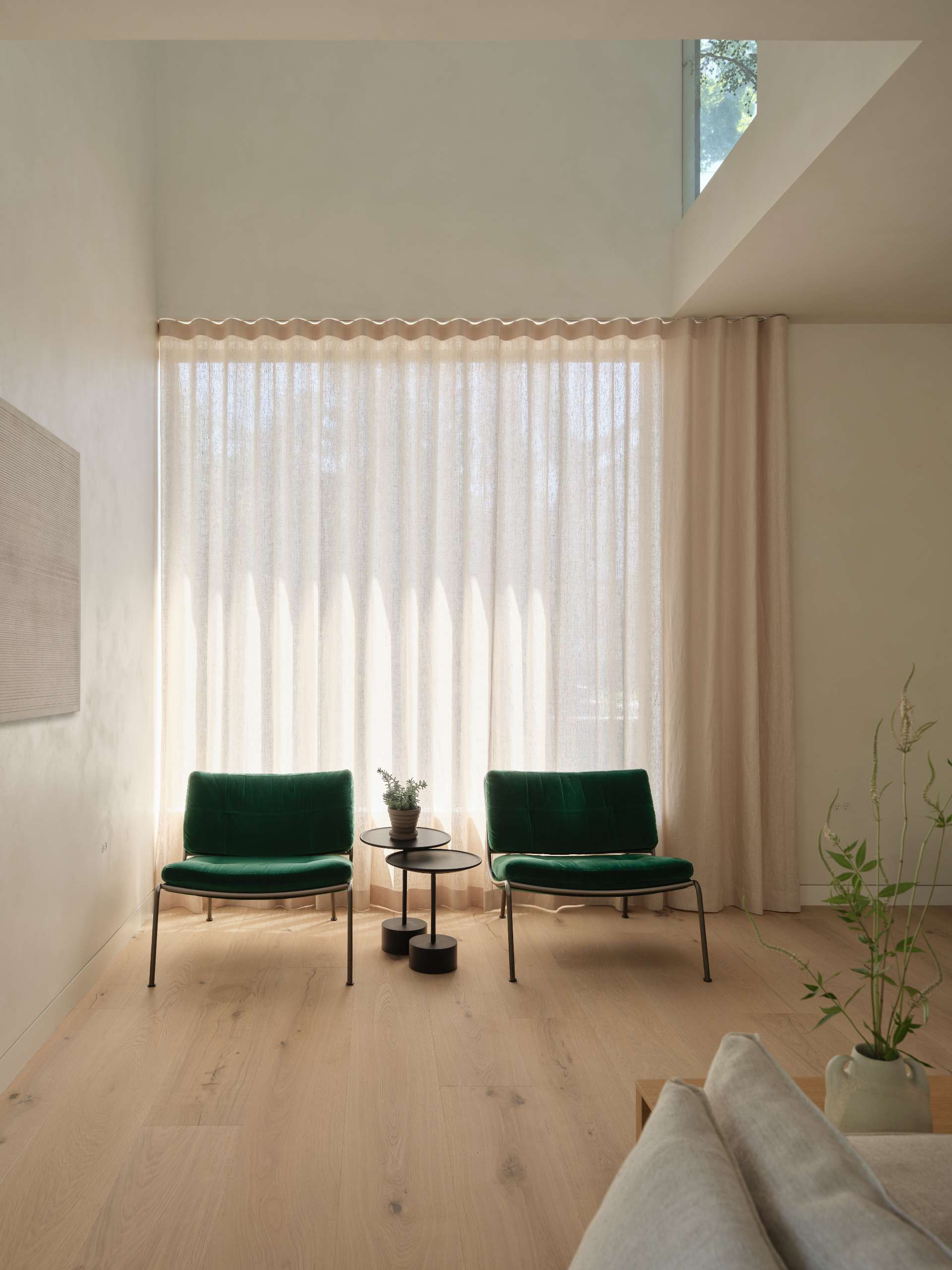 Natural light filters through large openings, highlighting the interplay of materials and enhancing this living room's dynamic character.