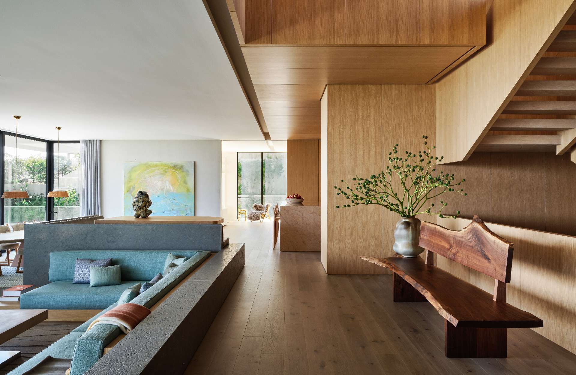 Natural light floods the warm and partially wood-clad interior, where clean lines and minimalist furnishings emphasize craftsmanship and comfort.