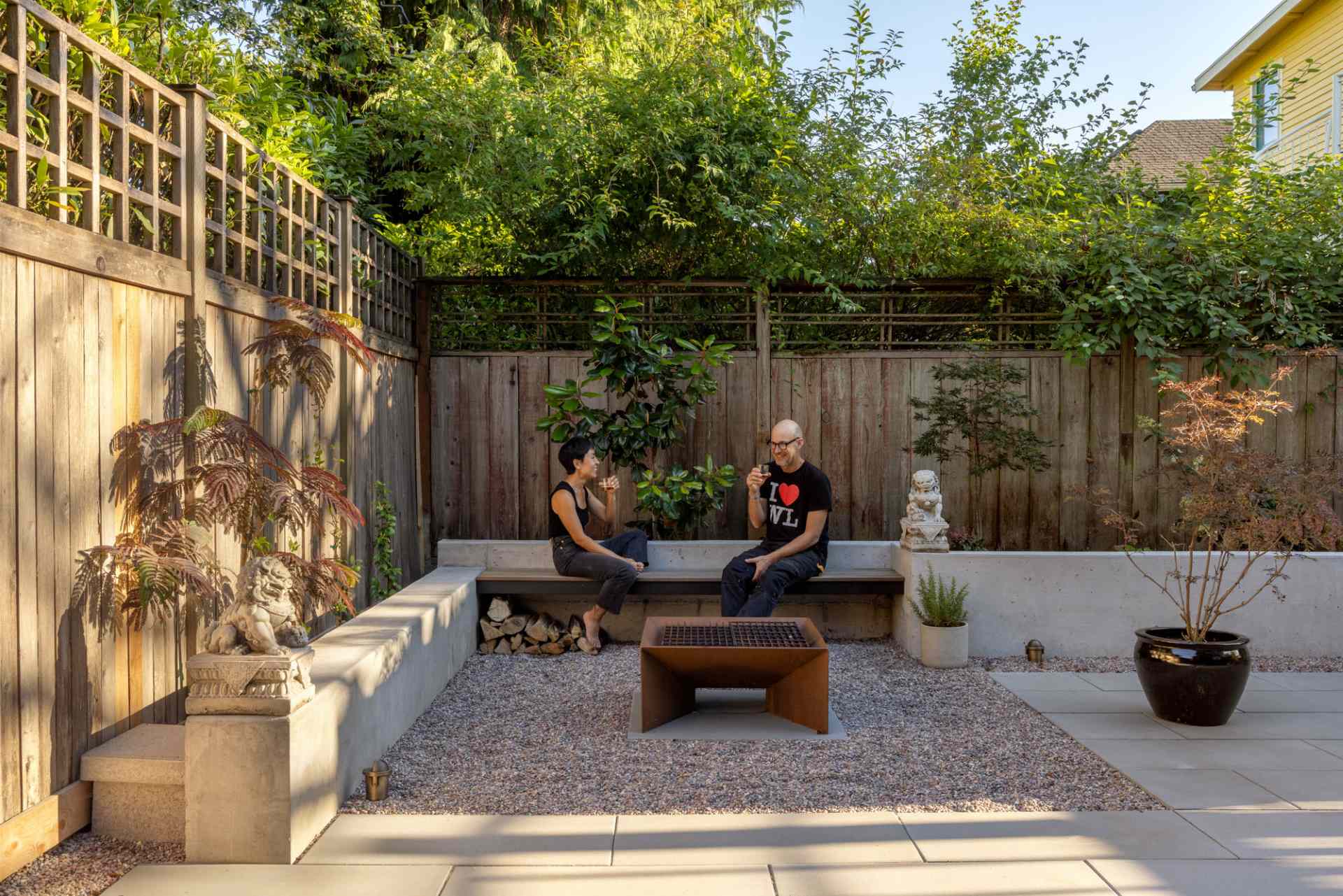 A contemporary patio with an outdoor fire and concrete benches.