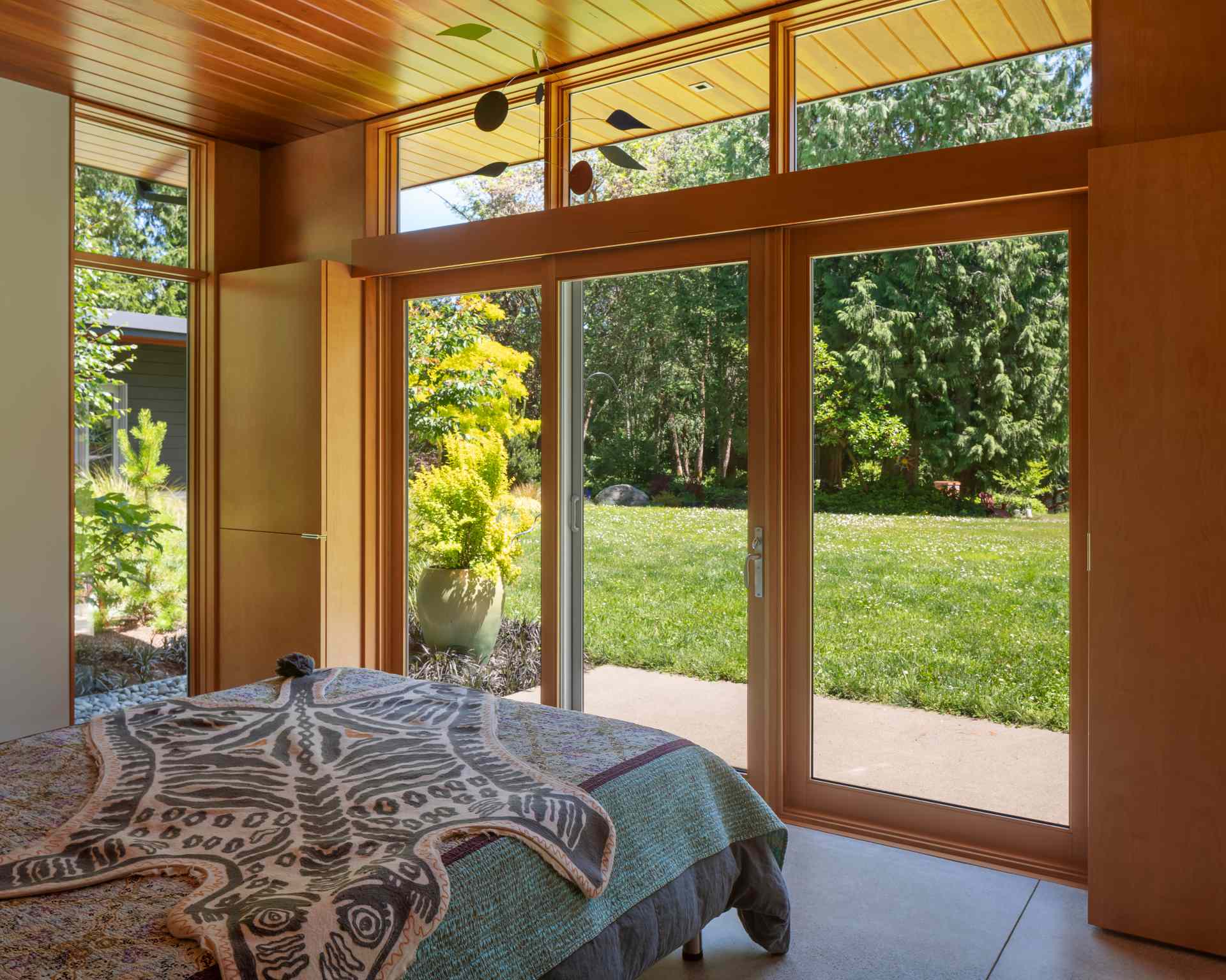 A modern bedroom with floor-to-ceiling windows.
