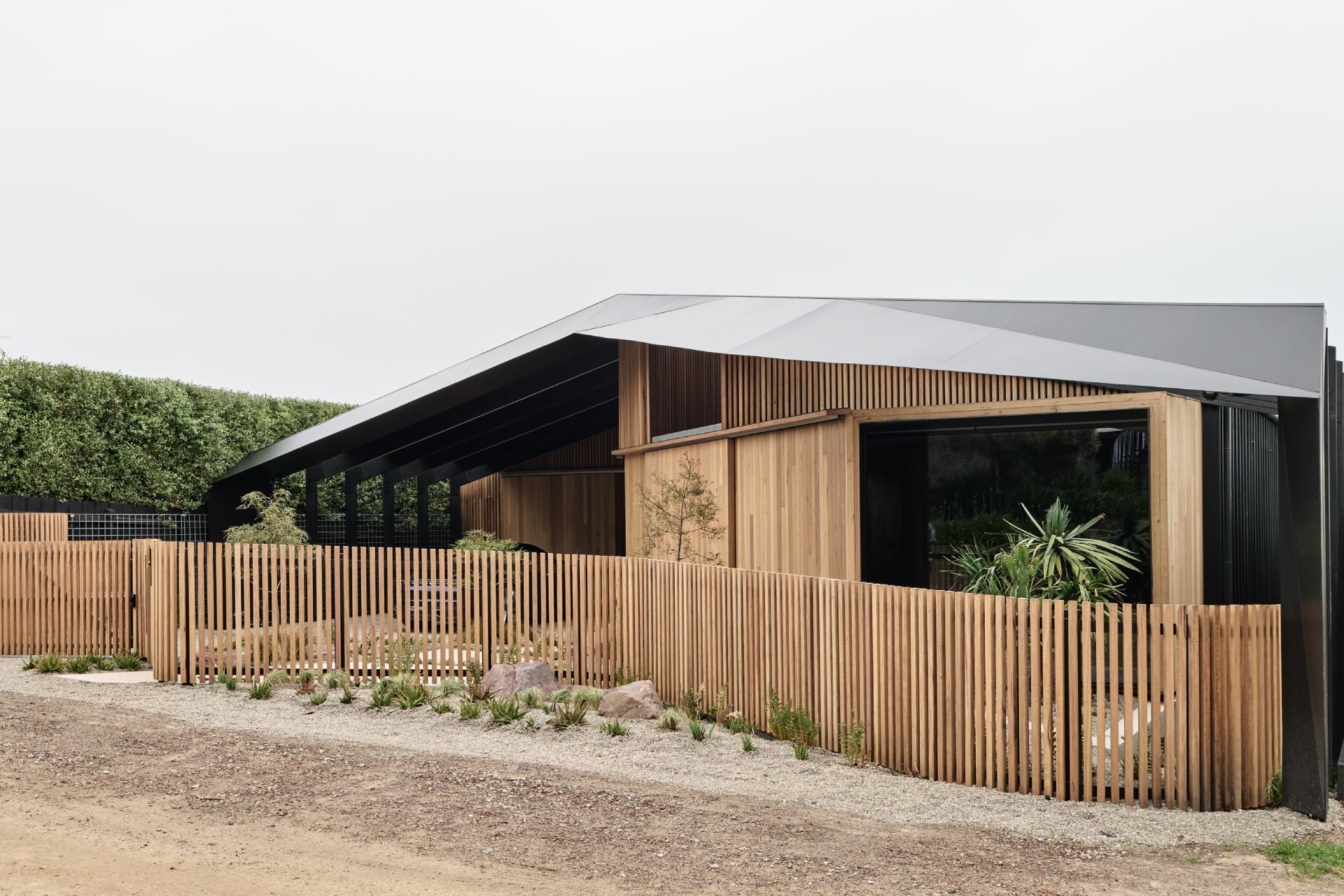 This striking facade balances bold geometry with natural warmth. Wrapped in Blackbutt shiplap cladding, the exterior feels soft and organic, while the dark Trimdeck Colorbond roof adds drama and definition with its sharp, clean lines.
