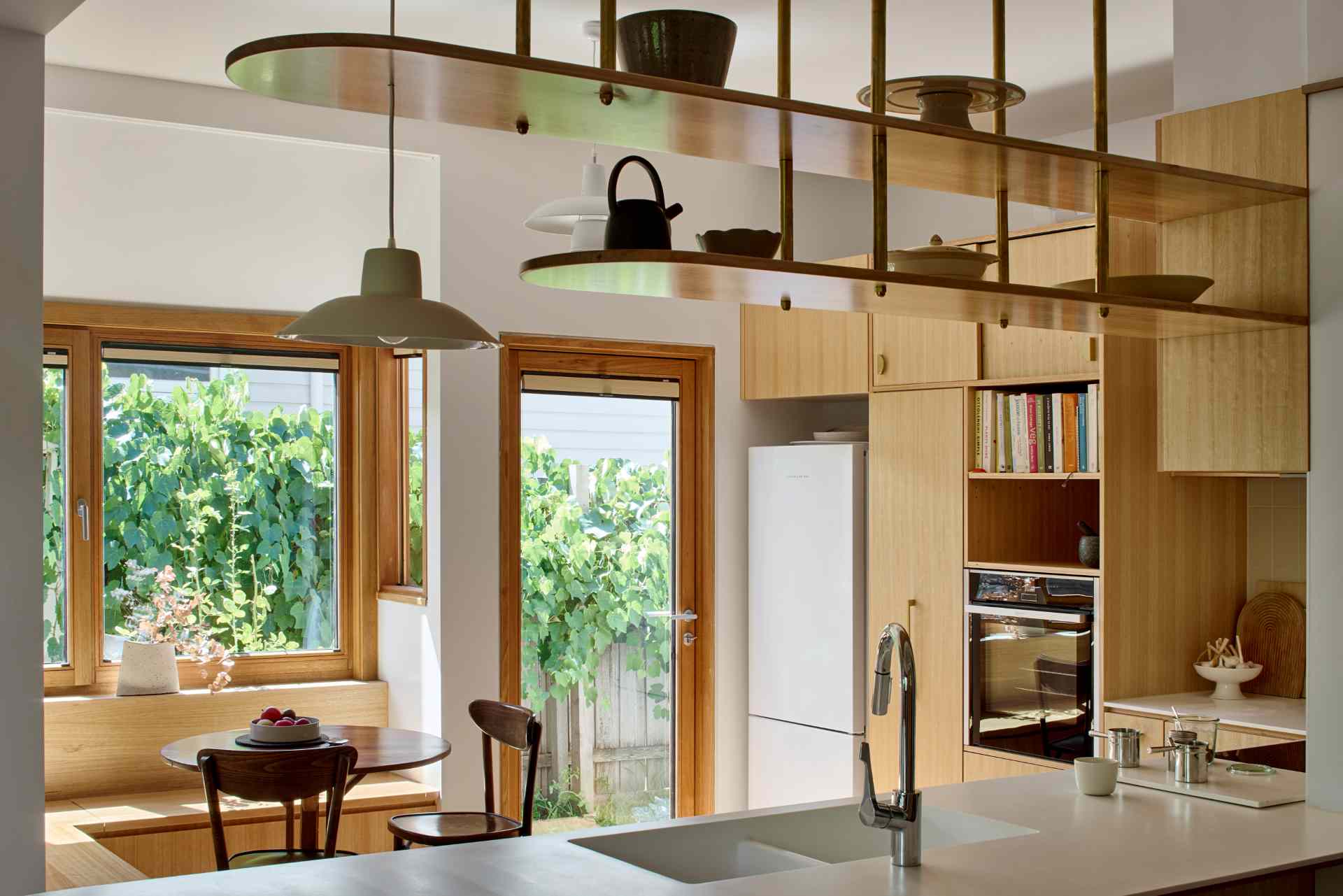A built-in breakfast nook with wood seating and views of the garden.