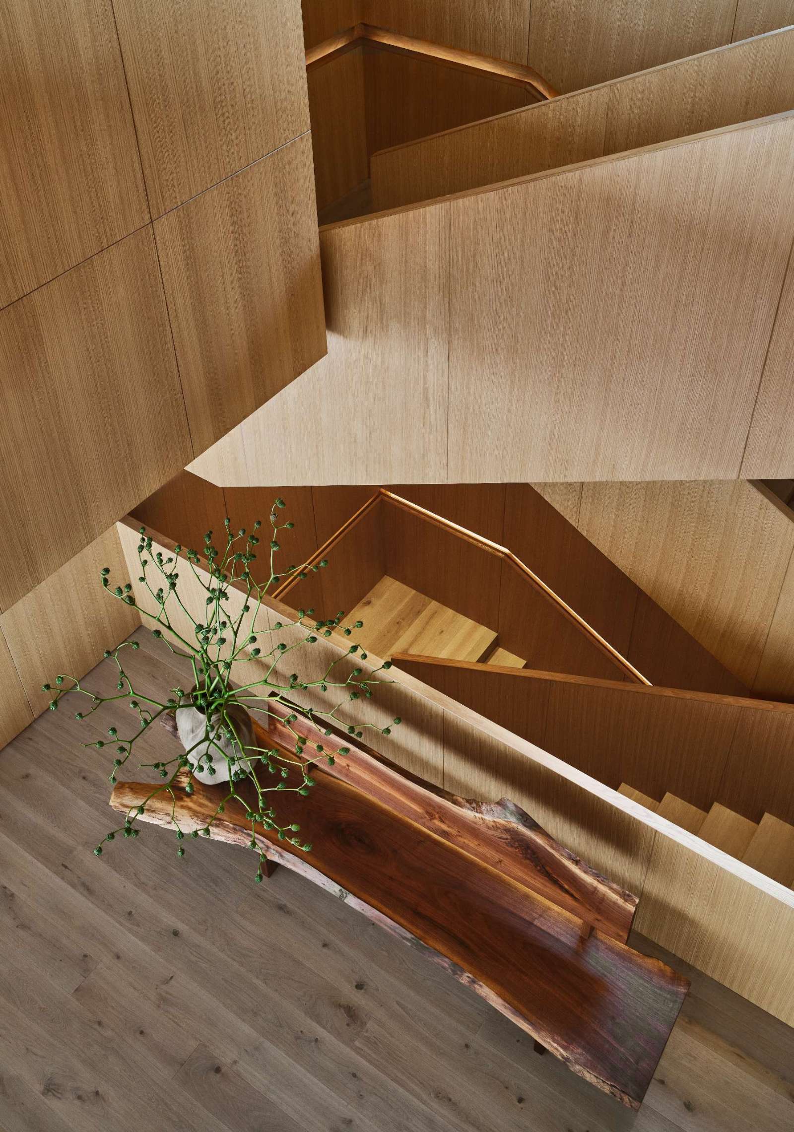 Wood stairs lead from the front door down to the social areas of the home.