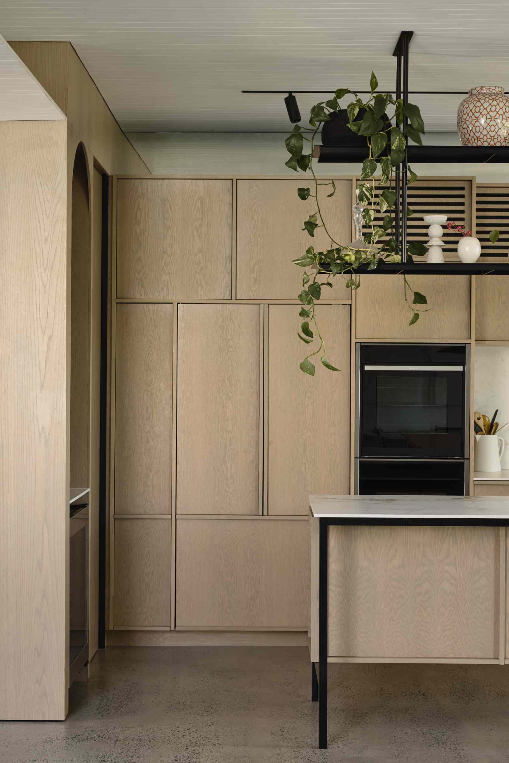 In the kitchen, custom American Oak Crown Cut Veneer has been used for the cabinets, while Neolith Abu Dhabi White Silk porcelain slabs have been used for the countertops.
