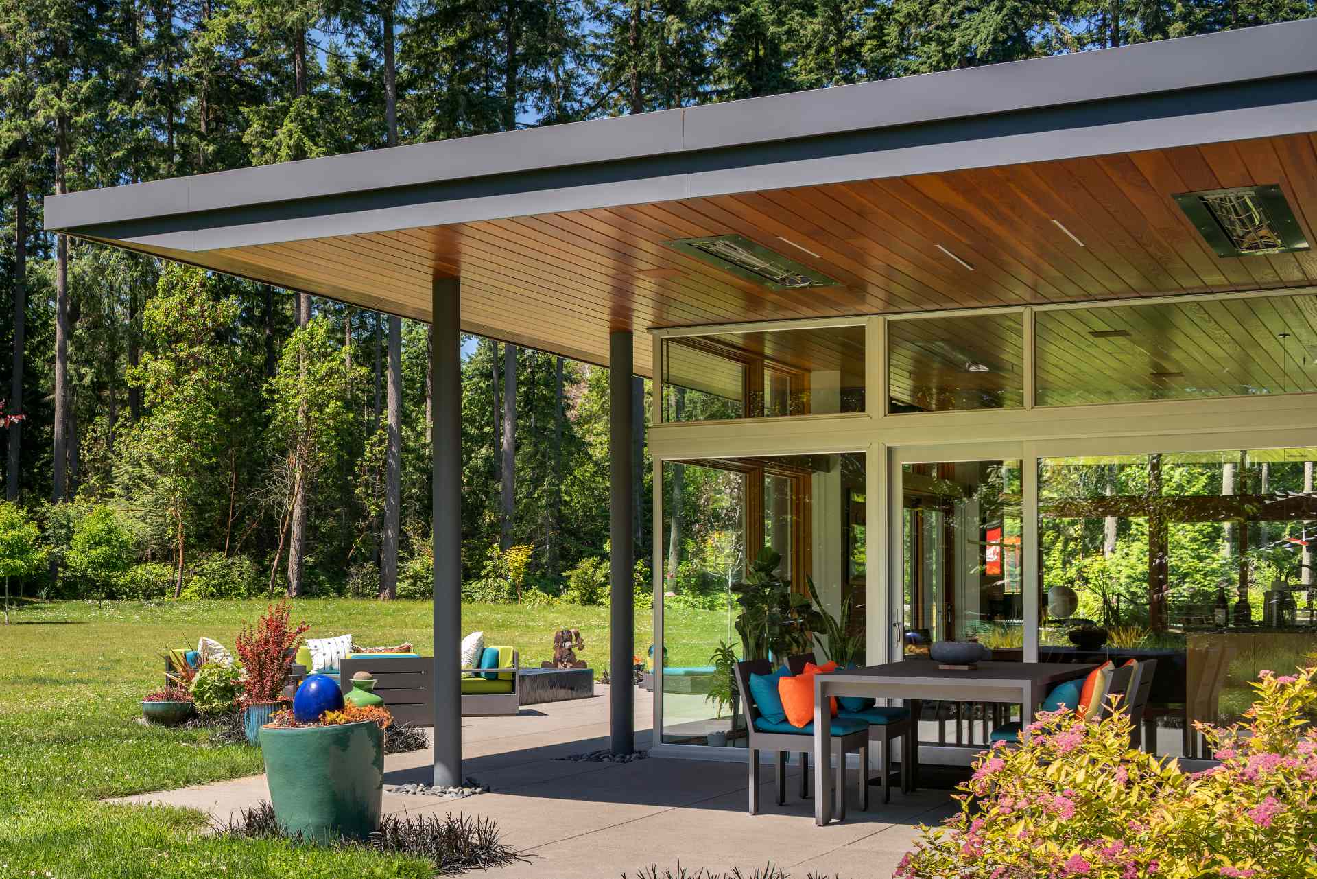 A modern home with a patio that's covered by the expansive roof.