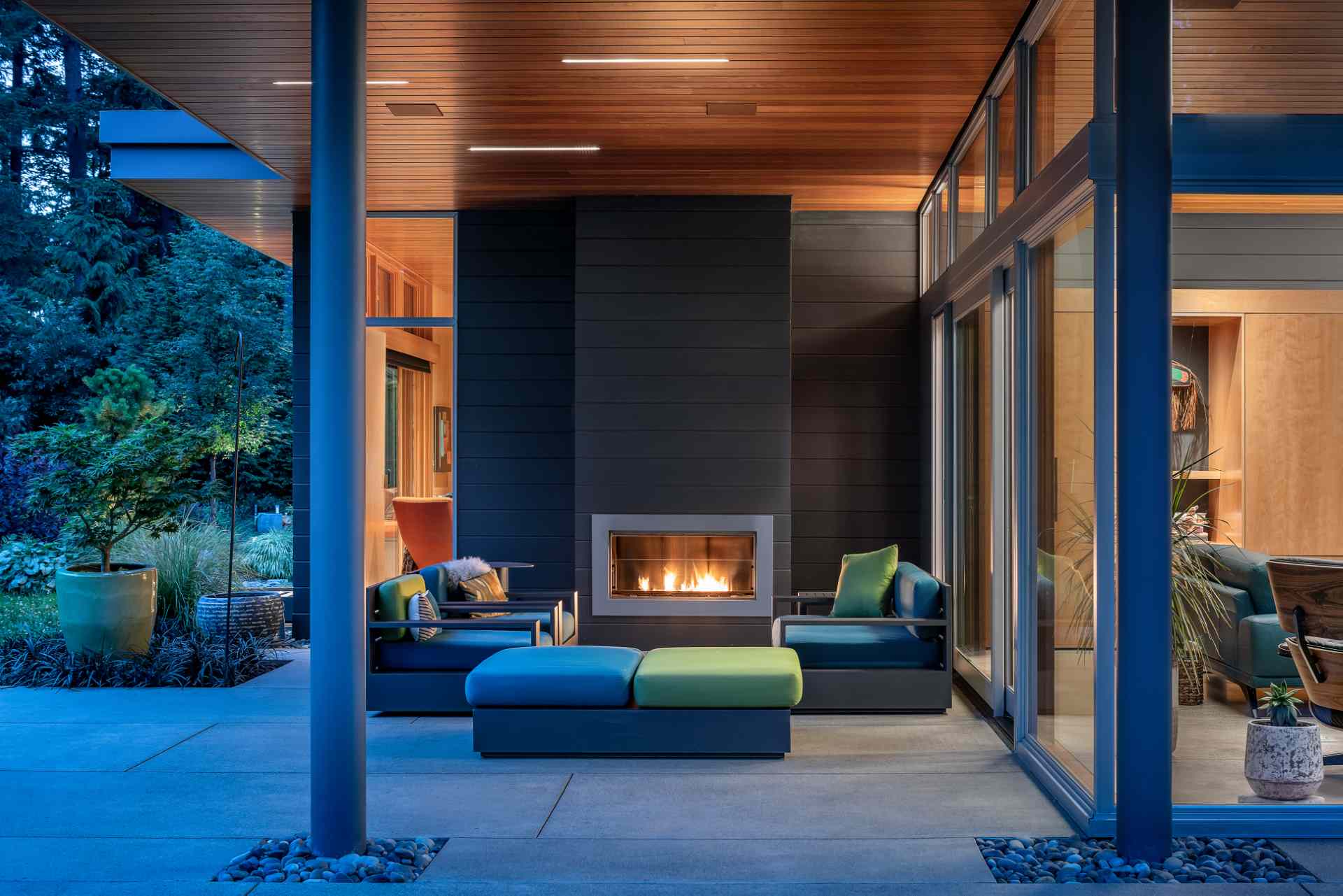 A modern home with a patio that's covered by the expansive roof.