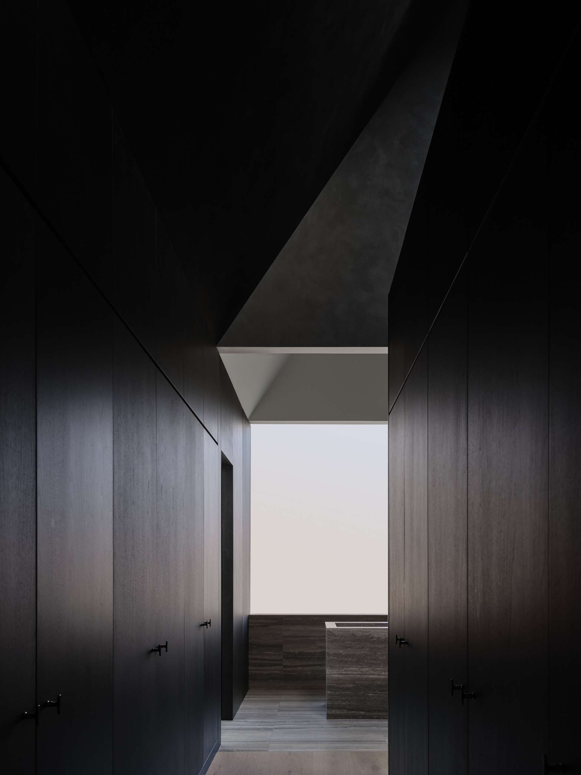 A walk-through closet in a modern primary suite.