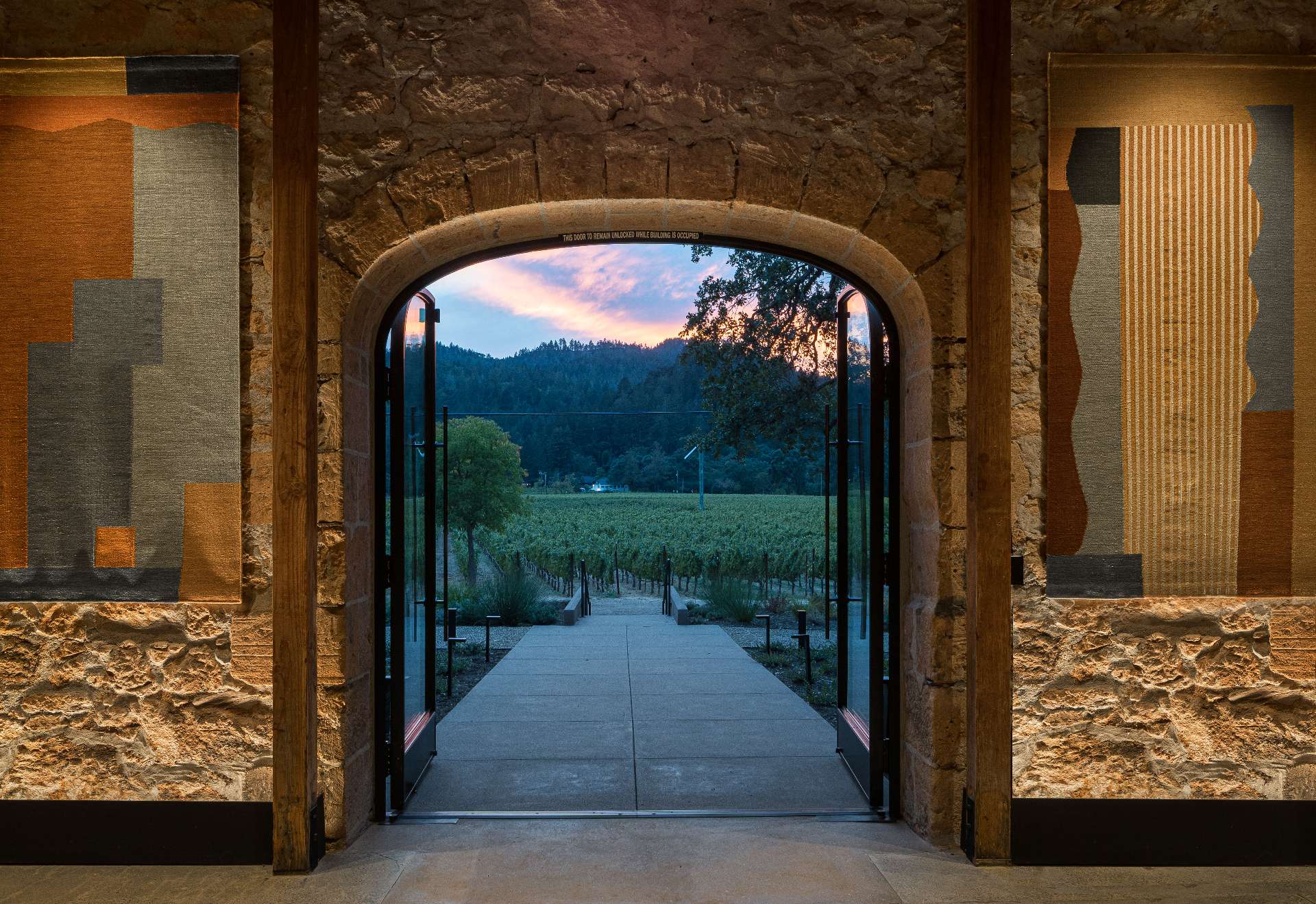 Custom steel doors and windows, crafted by local artisan Joel Cook, ground this wine tasting room in the region’s artisanal tradition while elevating its architectural character.