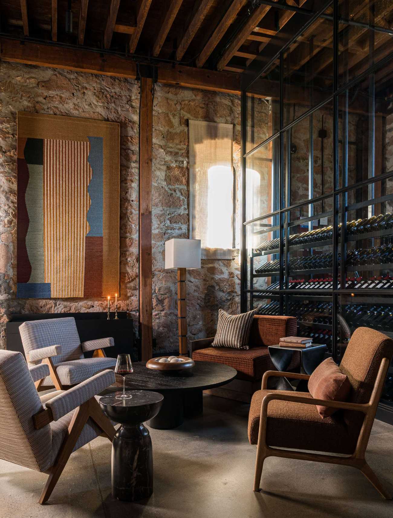 The existing concrete slab floor of this wine tasting room was polished, transforming it into a striking foundation that complements the room’s historic bones.