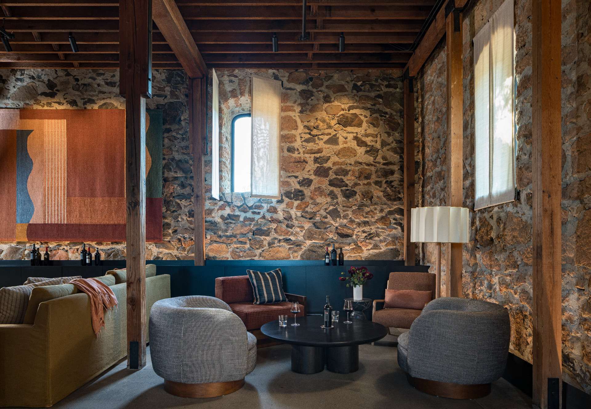 Lighting played a crucial role in the redesign of this Napa Valley wine tasting room. To soften the intensity of the southern light, the team introduced bespoke shutters made from sheer Trevira fabric by Dedar Milano, offering both elegance and function.
