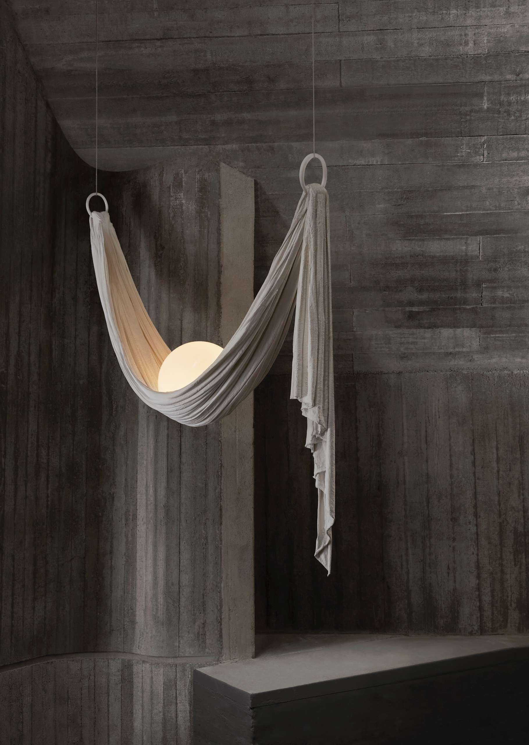 The Requiem Light Collection is handcrafted in plaster using a unique sculpting technique, capturing the fluidity of draped fabric in a striking form.