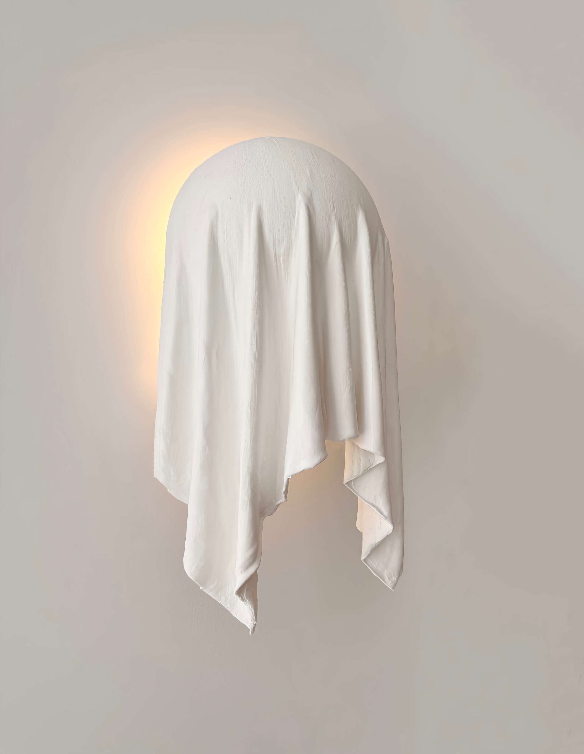The Requiem Wall Light, handcrafted in plaster using a unique sculpting technique, captures the fluidity of draped fabric in a striking wall-mounted form.