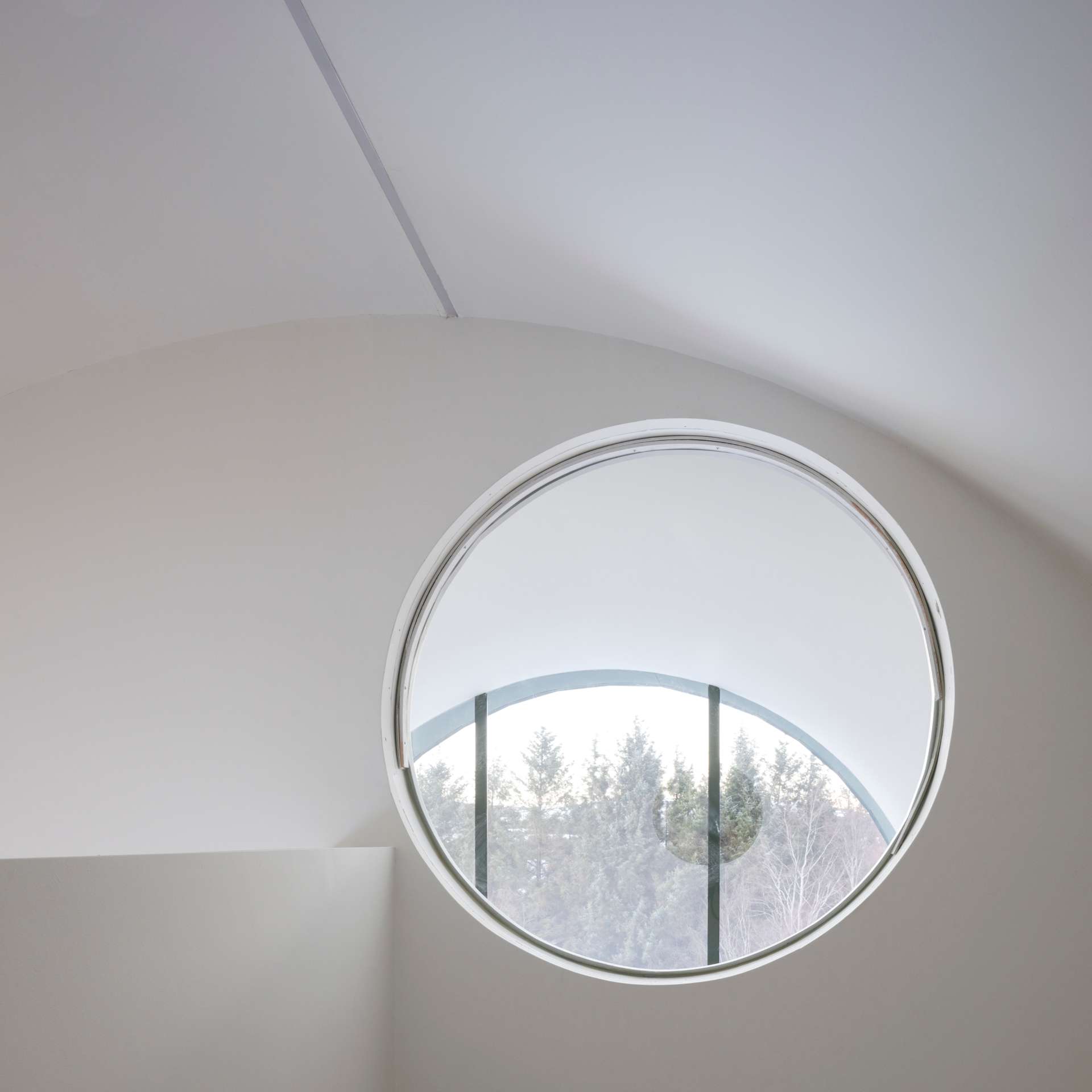 A contemporary home with a round window.