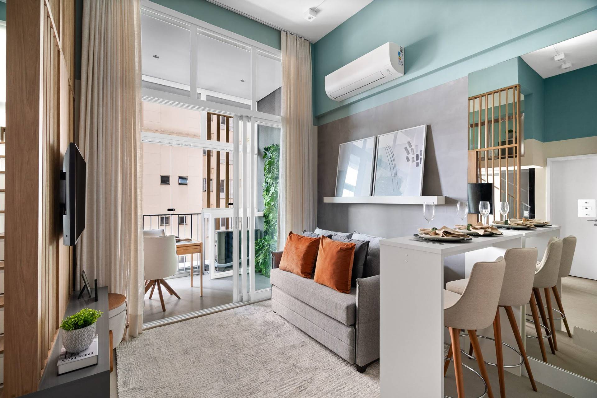 A neutral yet textured palette helps bring a sense of cohesion and calm to the living room of this small apartment. Shades of gray, white and light wood dominate, with layered finishes adding visual interest. Linen curtains have been used to soften the modern geometry, while various areas of the walls are painted in Suvinil’s Mantra, a muted gray with blue undertones. This subtle color shift helps define the vertical zones of the living area without overwhelming the space.