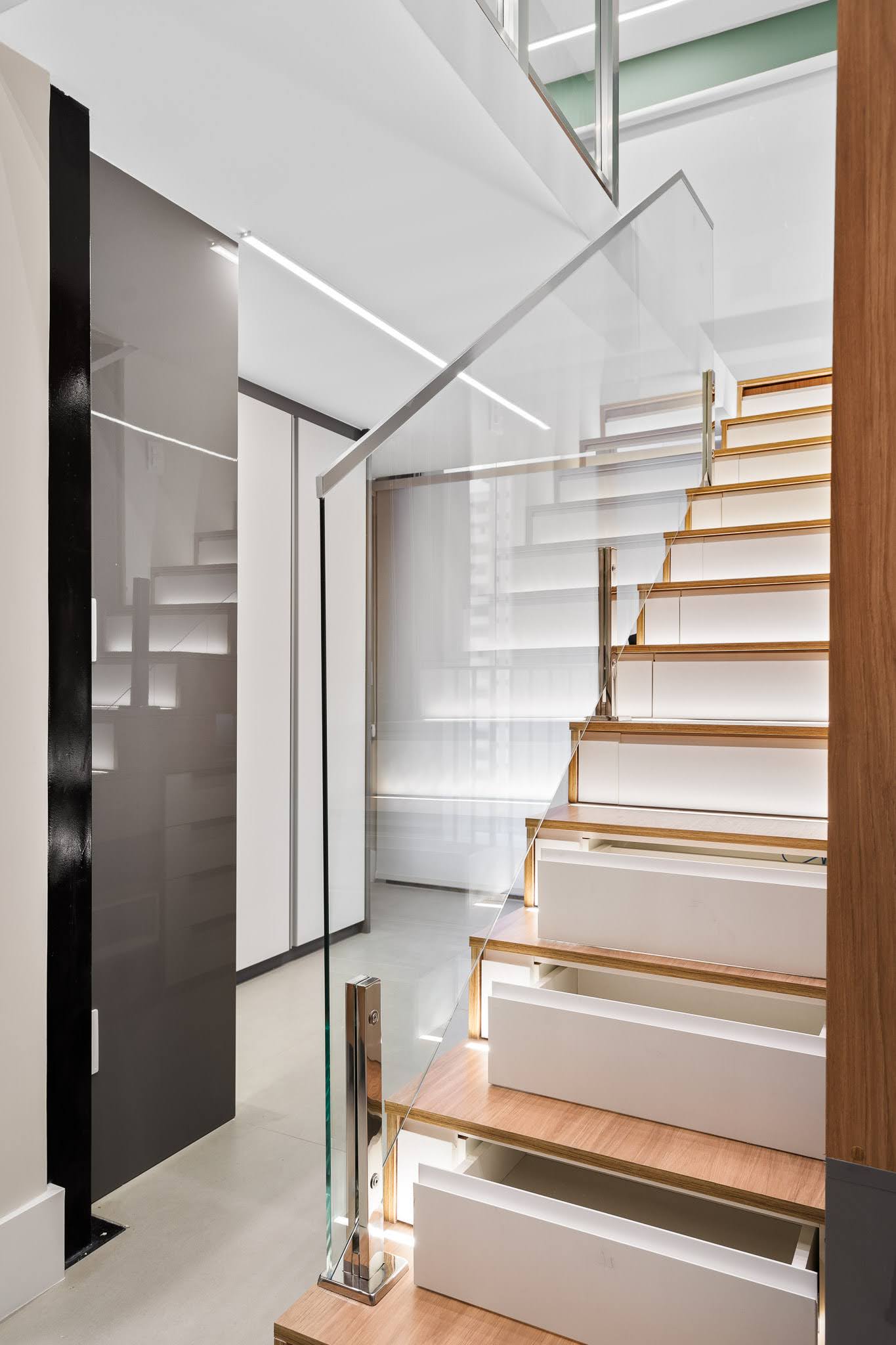 This staircase, fitted with drawer fronts and recessed lighting, functions as both circulation and storage.