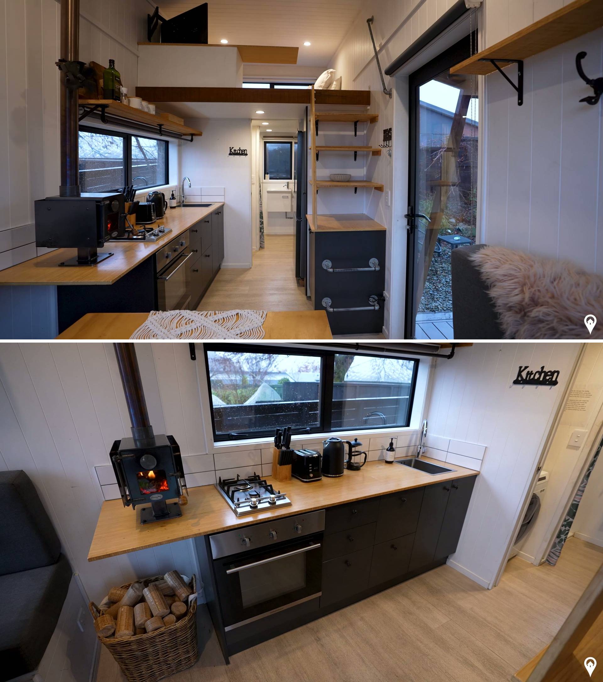 The kitchen in this tiny house includes a full-size oven, a gas cooktop, a microwave, and a Samsung fridge-freezer. A wood-burning fireplace, unusually compact and positioned on the countertop, helps warm the space during colder months. The cabinetry throughout is dark-toned, providing contrast against white painted walls.