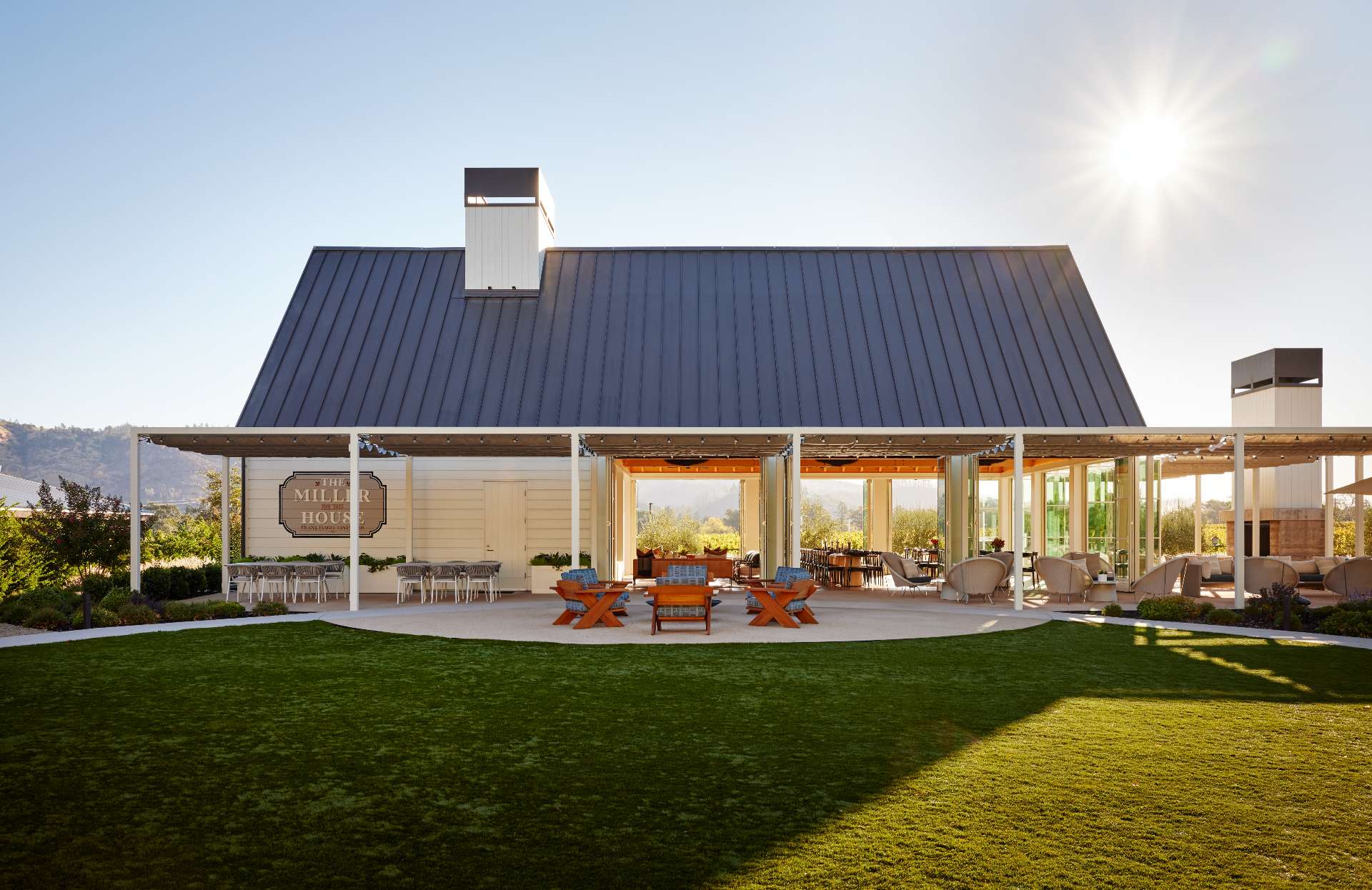 A single-room A-frame structure with high ceilings and a variety of seating areas, that's been designed for holding events, like weddings, at a winery.