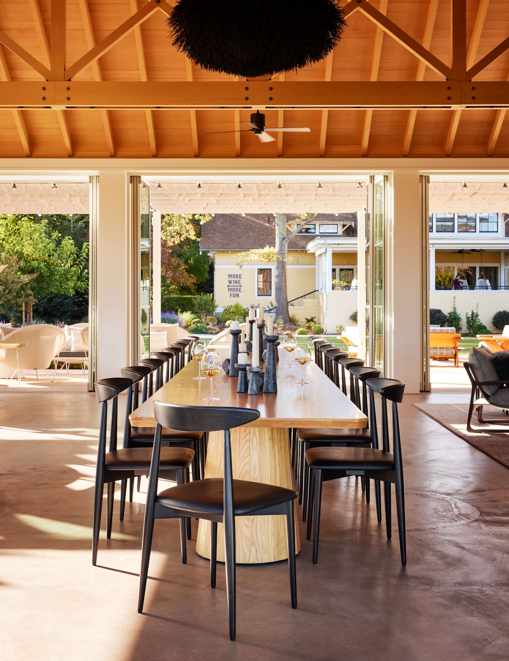 A single-room A-frame structure with high ceilings and a variety of seating areas, that's been designed for holding events, like weddings, at a winery.