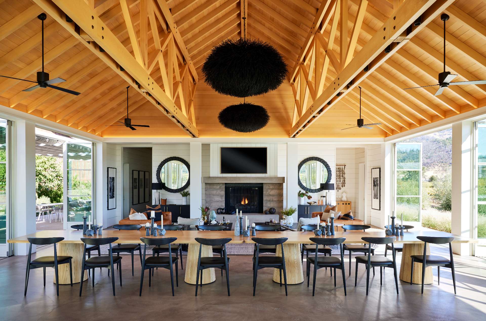 A single-room A-frame structure with high ceilings and a variety of seating areas, that's been designed for holding events, like weddings, at a winery.