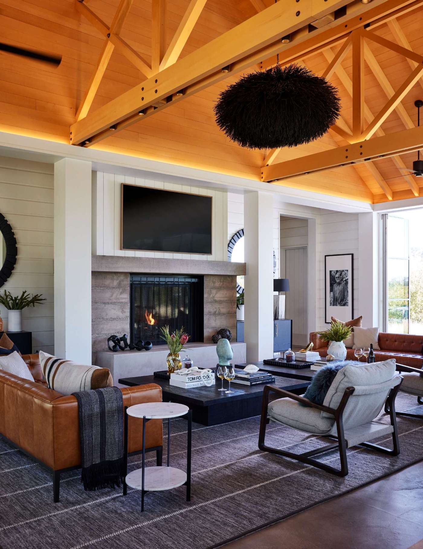 A single-room A-frame structure with high ceilings and a variety of seating areas, that's been designed for holding events, like weddings, at a winery.