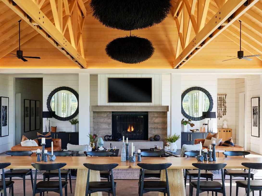 A single-room A-frame structure with high ceilings and a variety of seating areas, that's been designed for holding events, like weddings, at a winery.