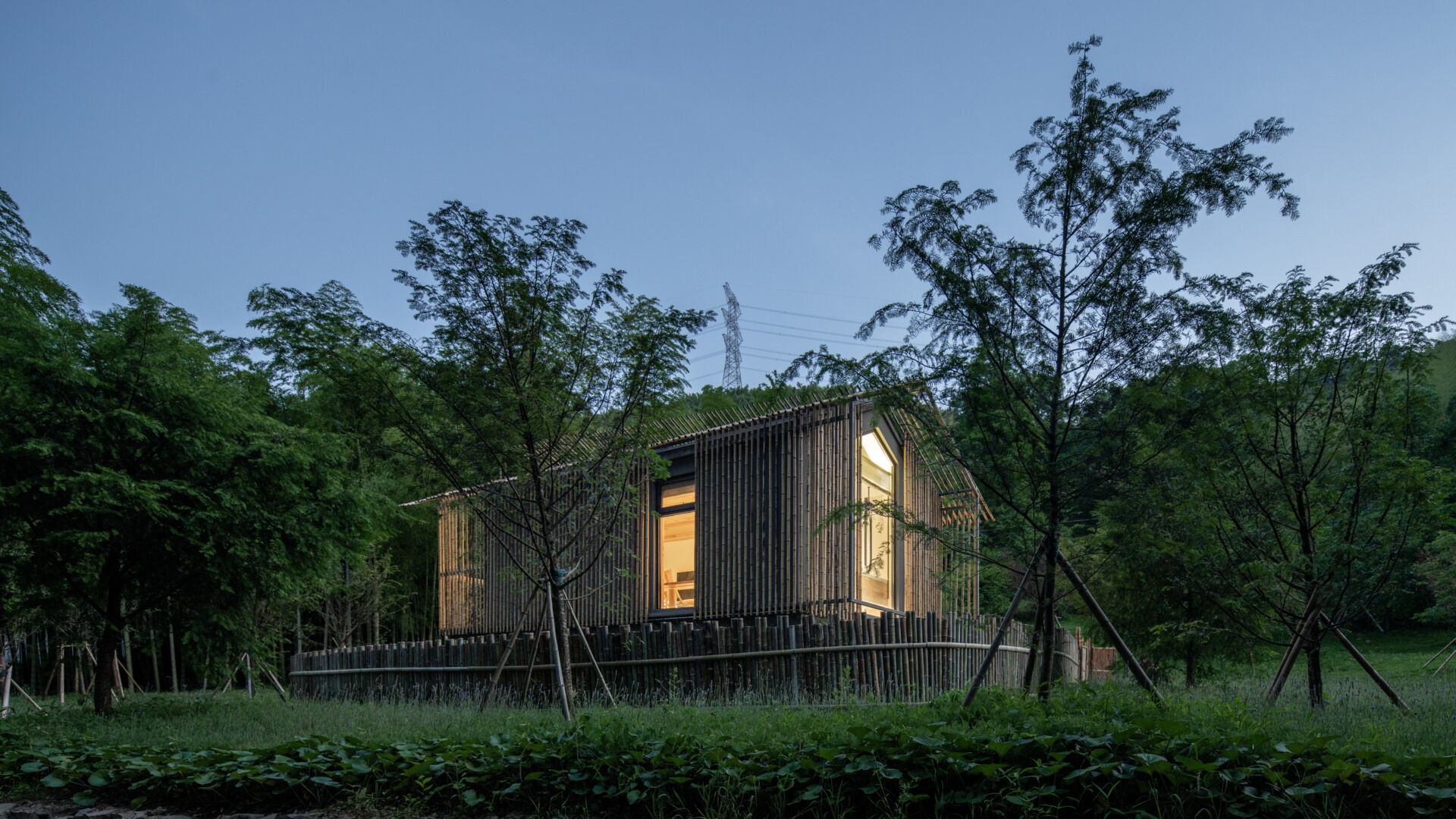 A minimalist bamboo hut on the forest’s edge create a seamless indoor-outdoor feel. The facade filters sunlight like tree canopies, wrapping guests in warm, natural textures.