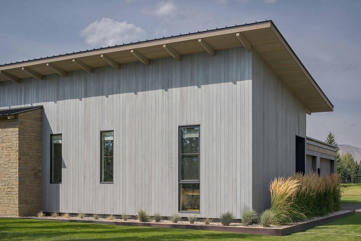 This modern barn-inspired mountain home features timeless materials like Montana sandstone and white oak, combining clean Scandinavian lines with subtle Southern detailing.