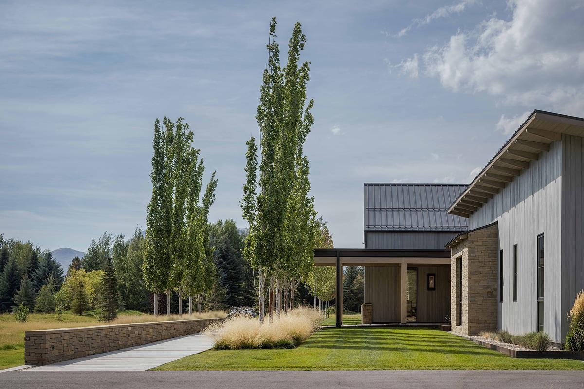This modern barn-inspired mountain home features timeless materials like Montana sandstone and white oak, combining clean Scandinavian lines with subtle Southern detailing.