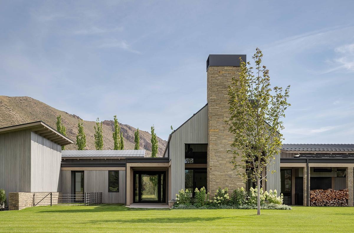 This modern barn-inspired mountain home features timeless materials like Montana sandstone and white oak, combining clean Scandinavian lines with subtle Southern detailing.