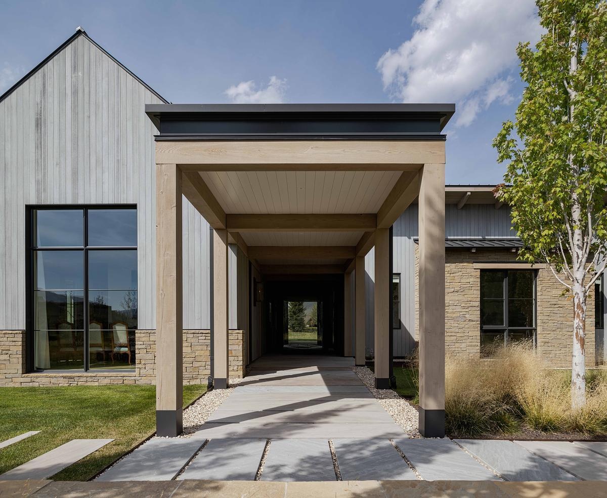 This modern barn-inspired mountain home features timeless materials like Montana sandstone and white oak, combining clean Scandinavian lines with subtle Southern detailing.