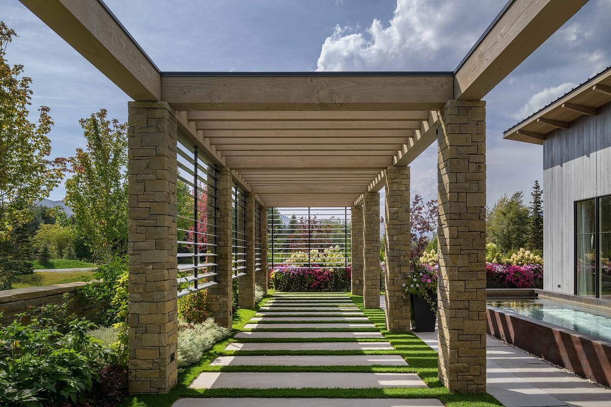 Native plantings, curated garden views, and layered outdoor spaces, like this pergola and lap pool, extend the home’s living area into the landscape with effortless grace.