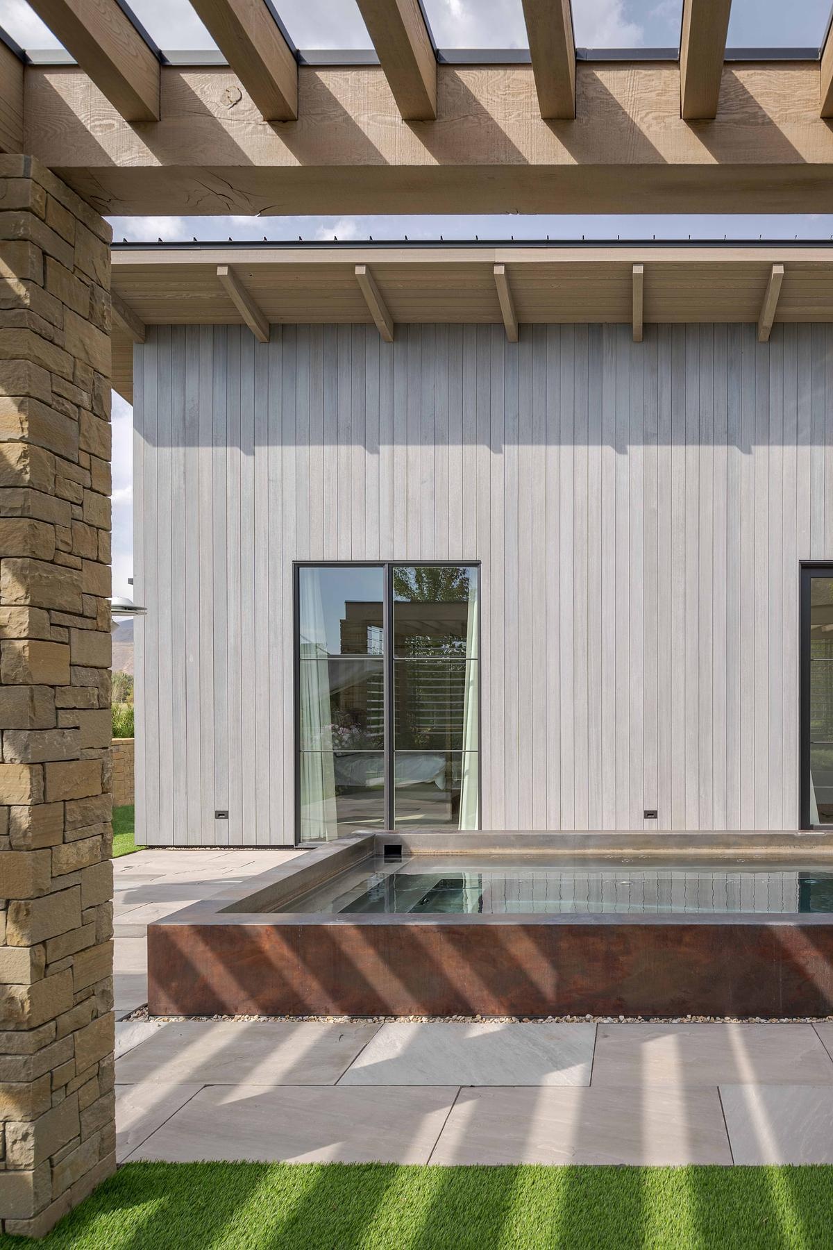 Native plantings, curated garden views, and layered outdoor spaces, like this pergola and lap pool, extend the home’s living area into the landscape with effortless grace.