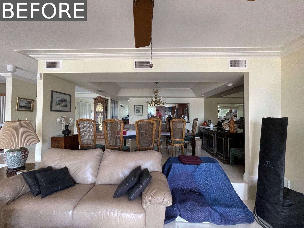 BEFORE - The original dining room was dominated by a large, oversized table and dark, bulky furniture. A full mirrored wall reflected an ornate chandelier overhead, giving the space a formal, almost imposing feel.