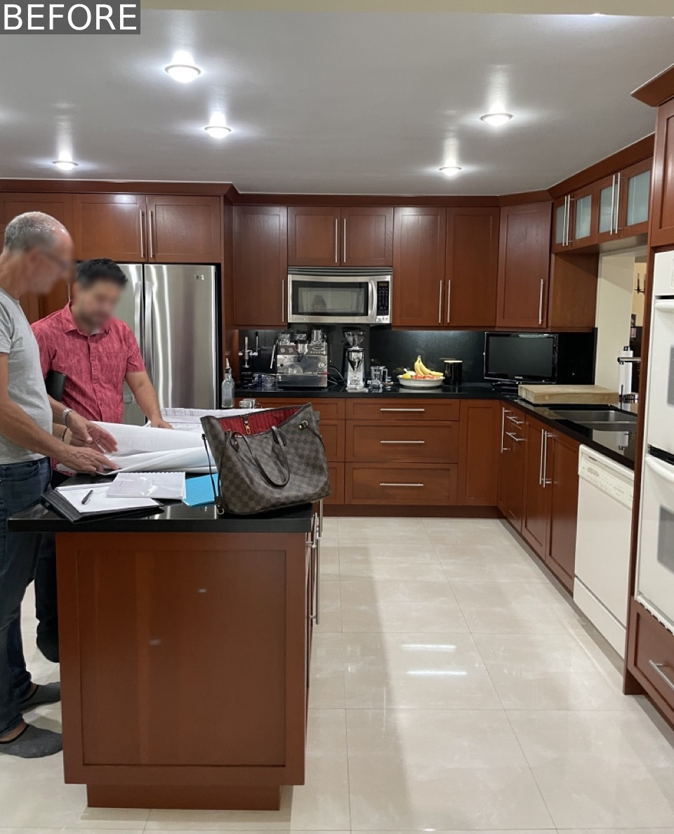 Before the renovation, the kitchen featured dark wood cabinetry and a matching island, all topped with black countertops that made the space feel heavy and closed in. The appliances were mismatched, some stainless steel, others white, making the kitchen lack a cohesive look.