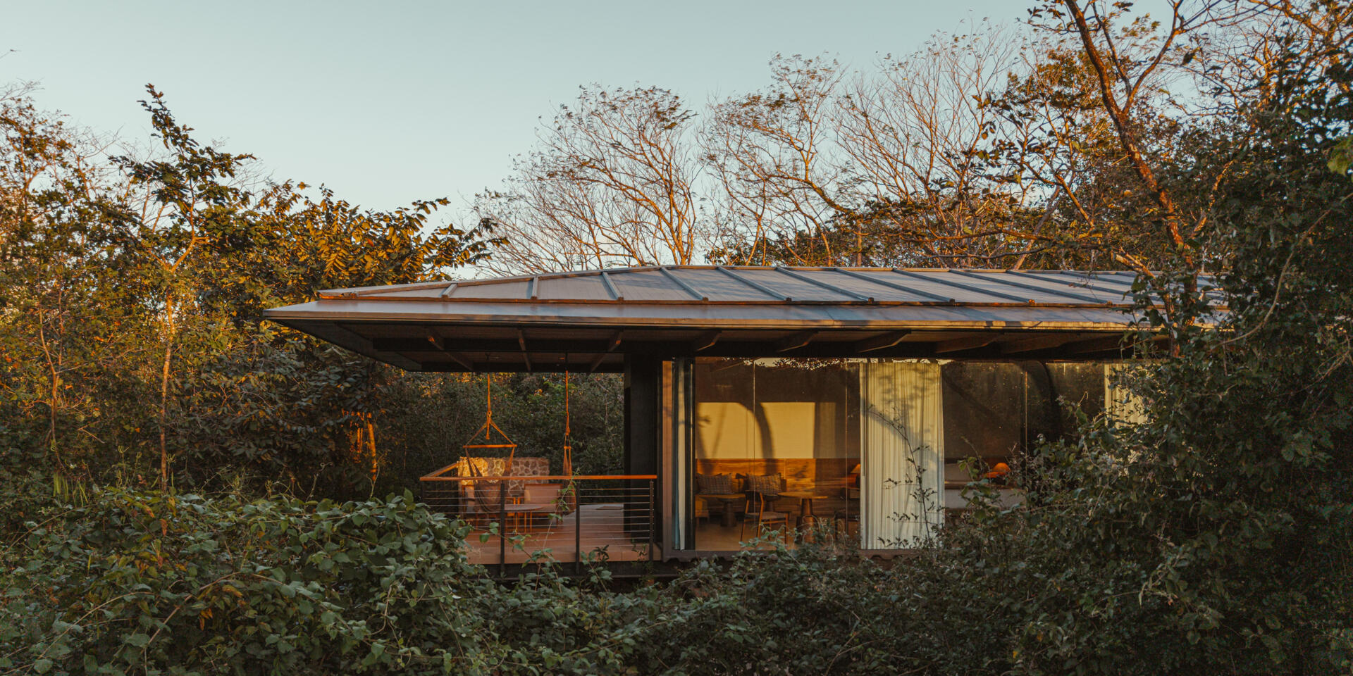 A stone, wood, and glass clad jungle bungalow in Costa Rica blends effortlessly into its forest surroundings.